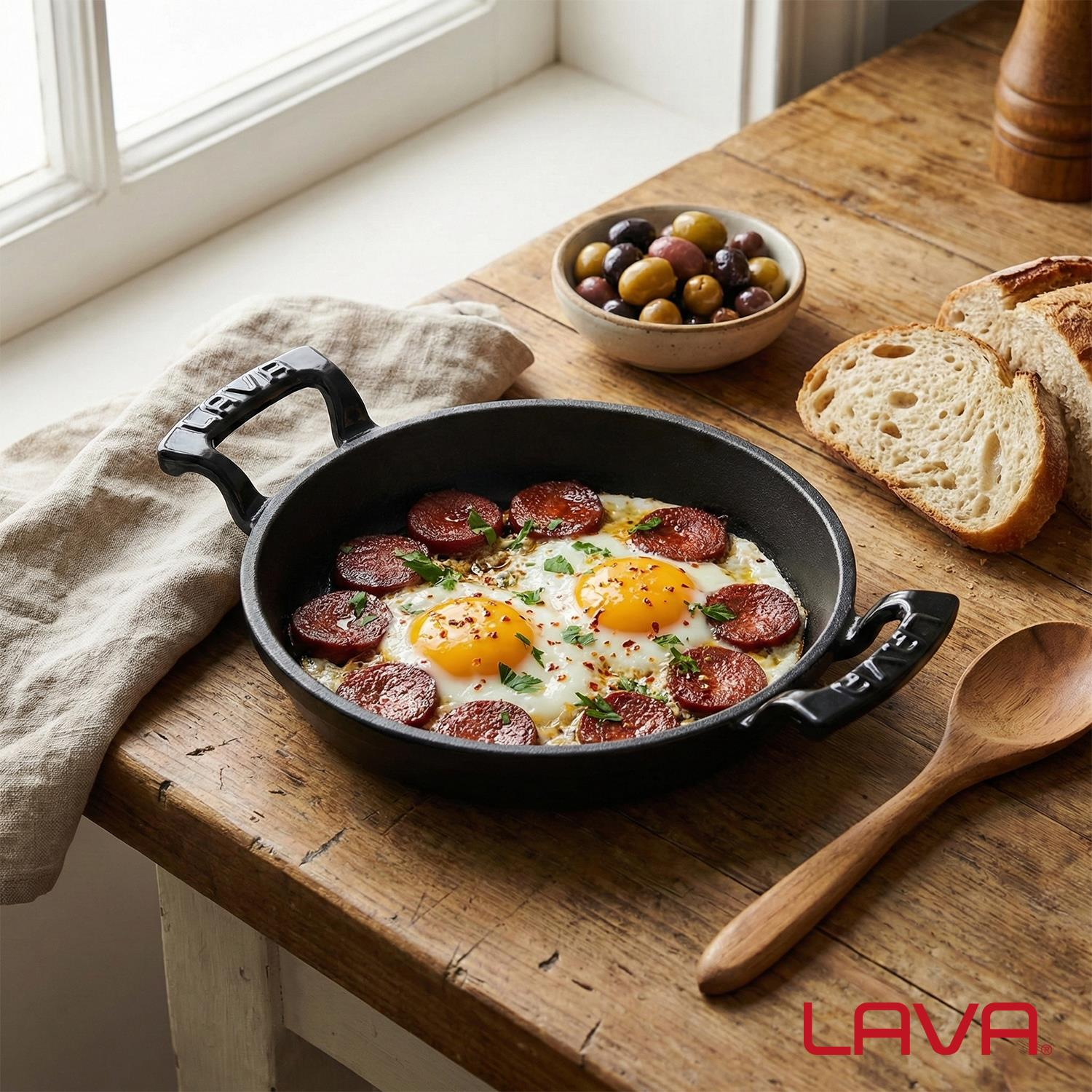 Siyah tavada chorizo dilimli sahanda yumurta, zeytin ve ekmek ile servis edilir.