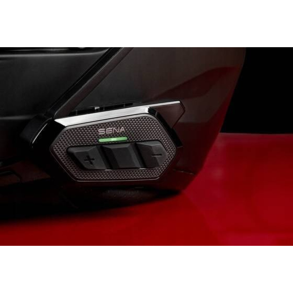 Zbliżenie czarnego mocowania kasku z logo Sena i zieloną diodą LED.