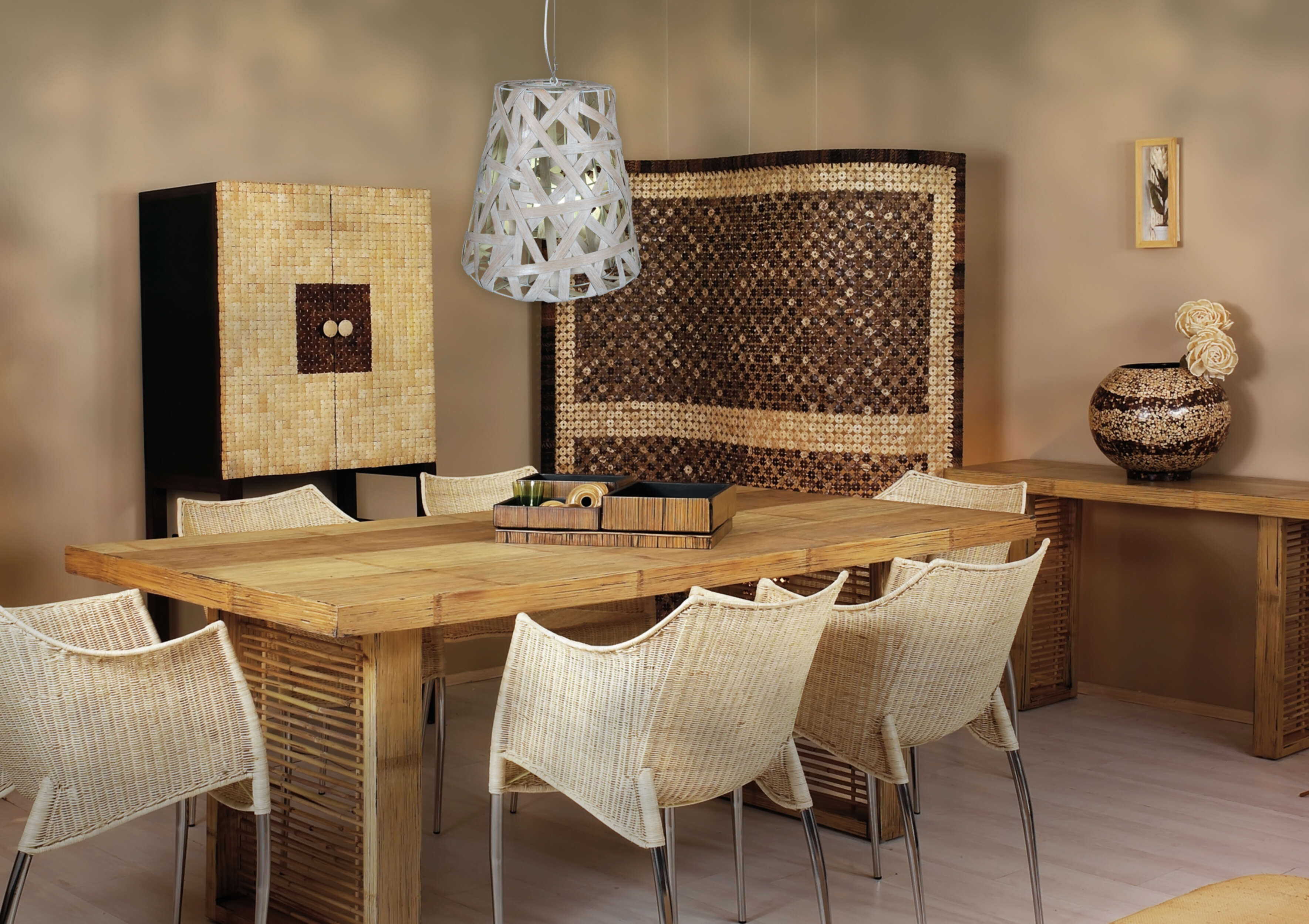 Esszimmer mit Holztisch, Korbstühlen, Schrank und Wanddekor.