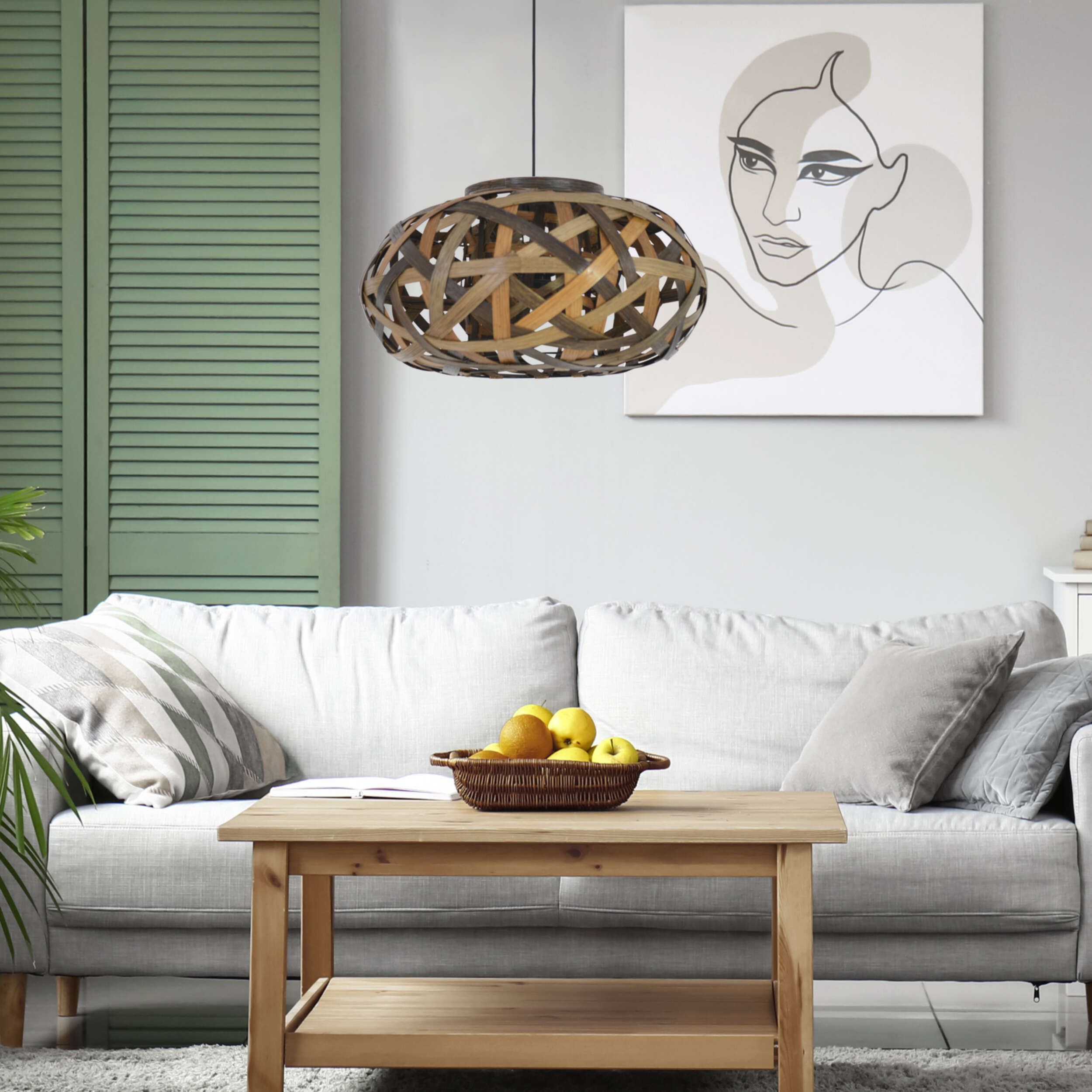 Ein Wohnzimmer mit Sofa, Couchtisch mit Obst und Kunst an der Wand.