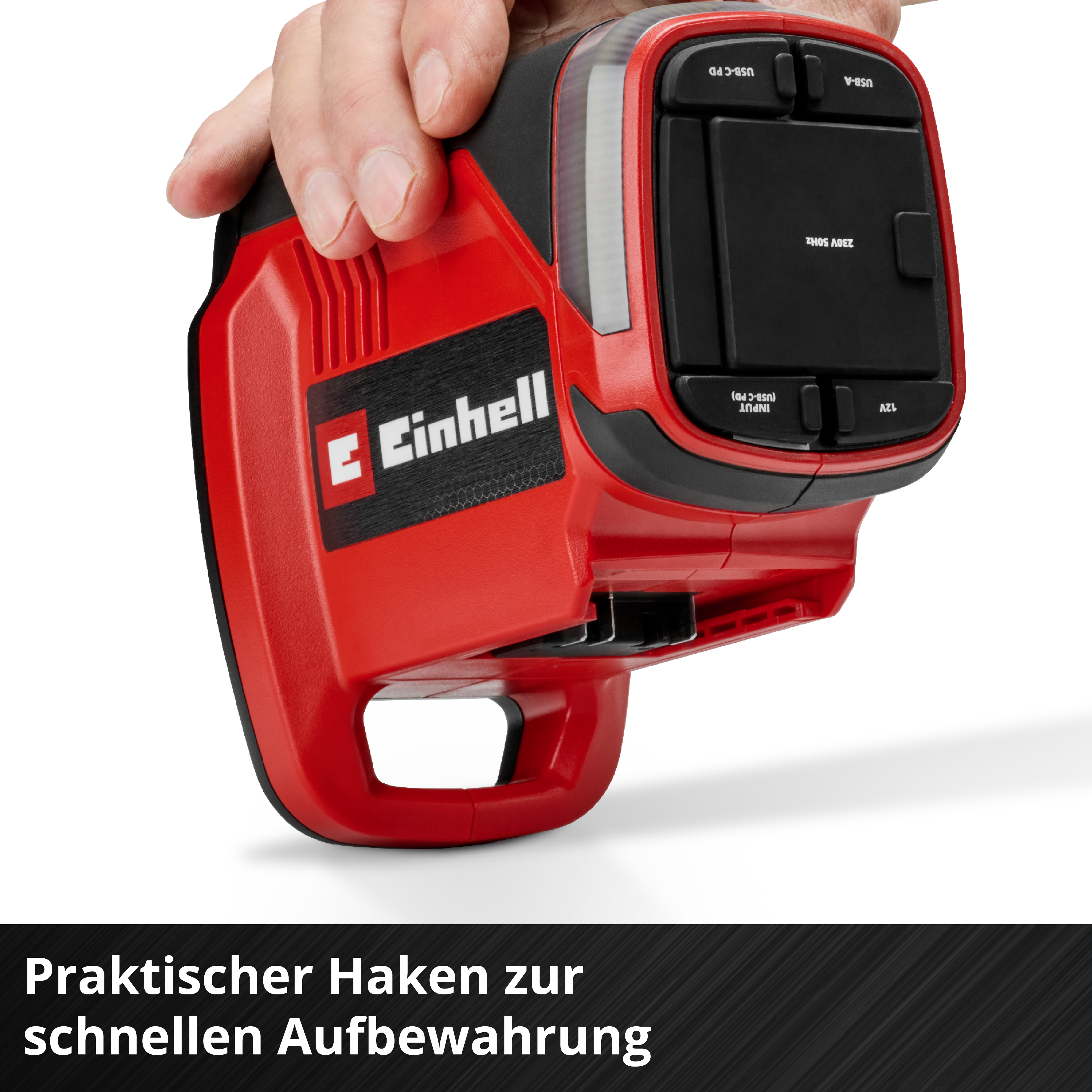 Ein rotes Einhell-Gerät mit USB-Anschlüssen wird von einer Hand gehalten.