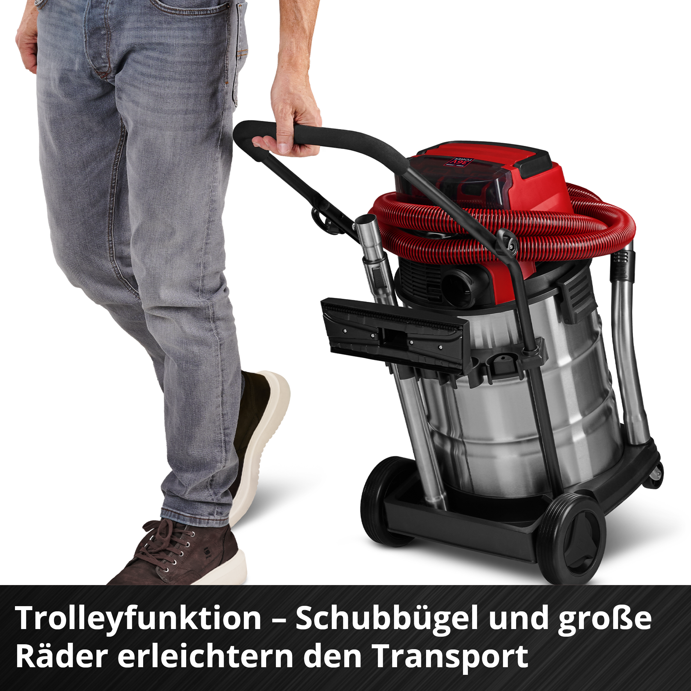 Mann zieht einen roten und silbernen Nass-/Trockensauger mit großen Rädern.