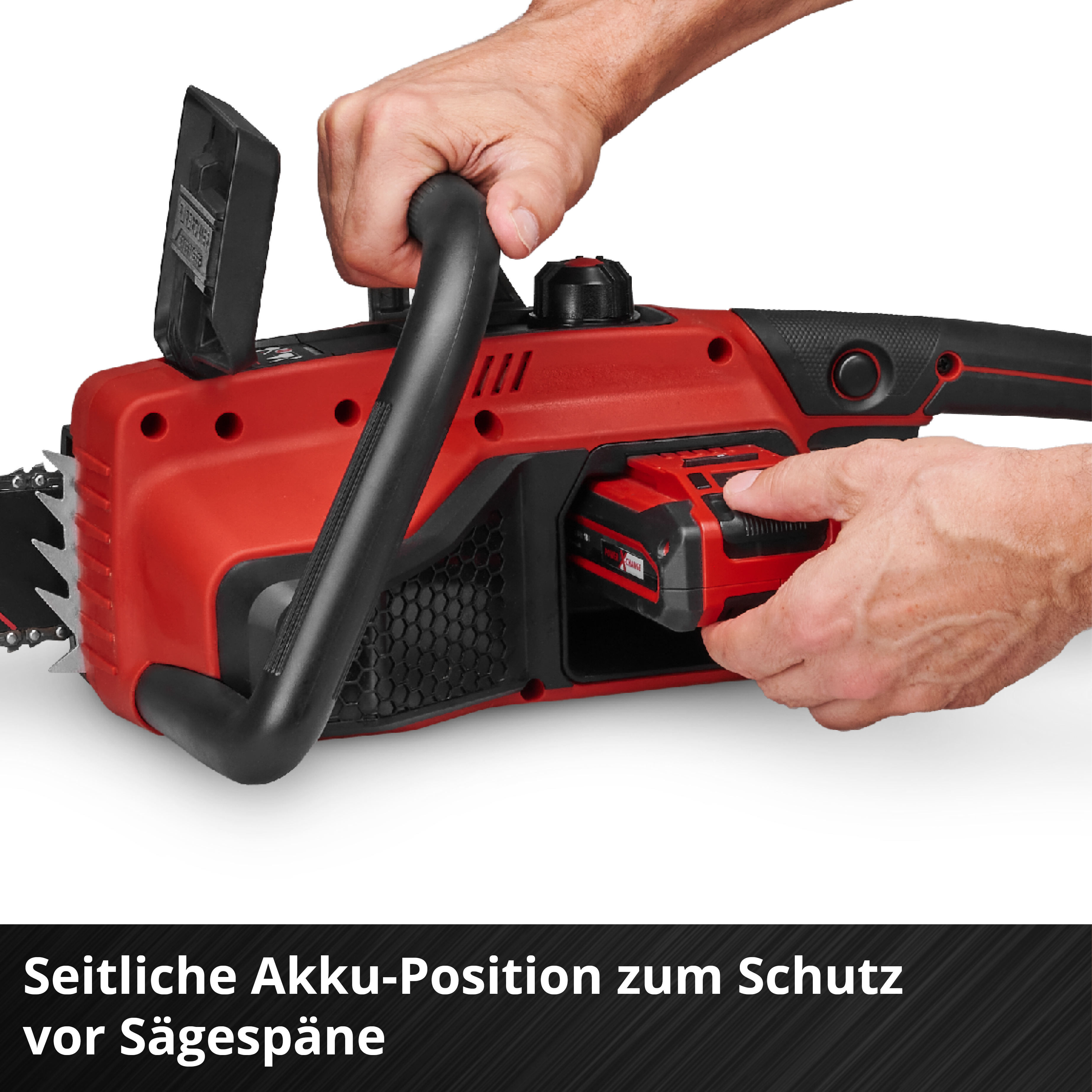 Hände setzen Akku in rote Kettensäge ein.