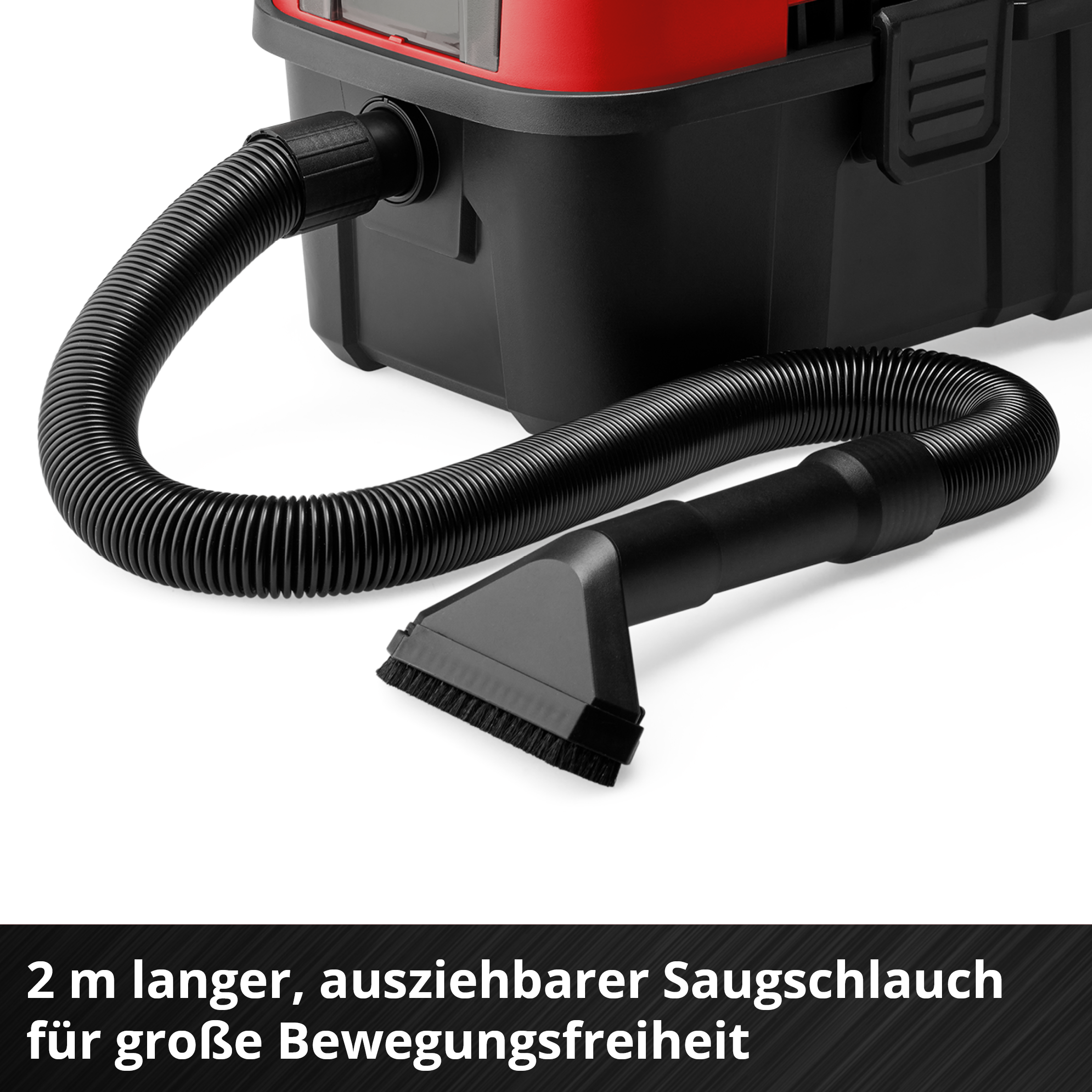 Schwarzer Saugschlauch mit Bürstenaufsatz an einem roten und schwarzen Staubsauger.