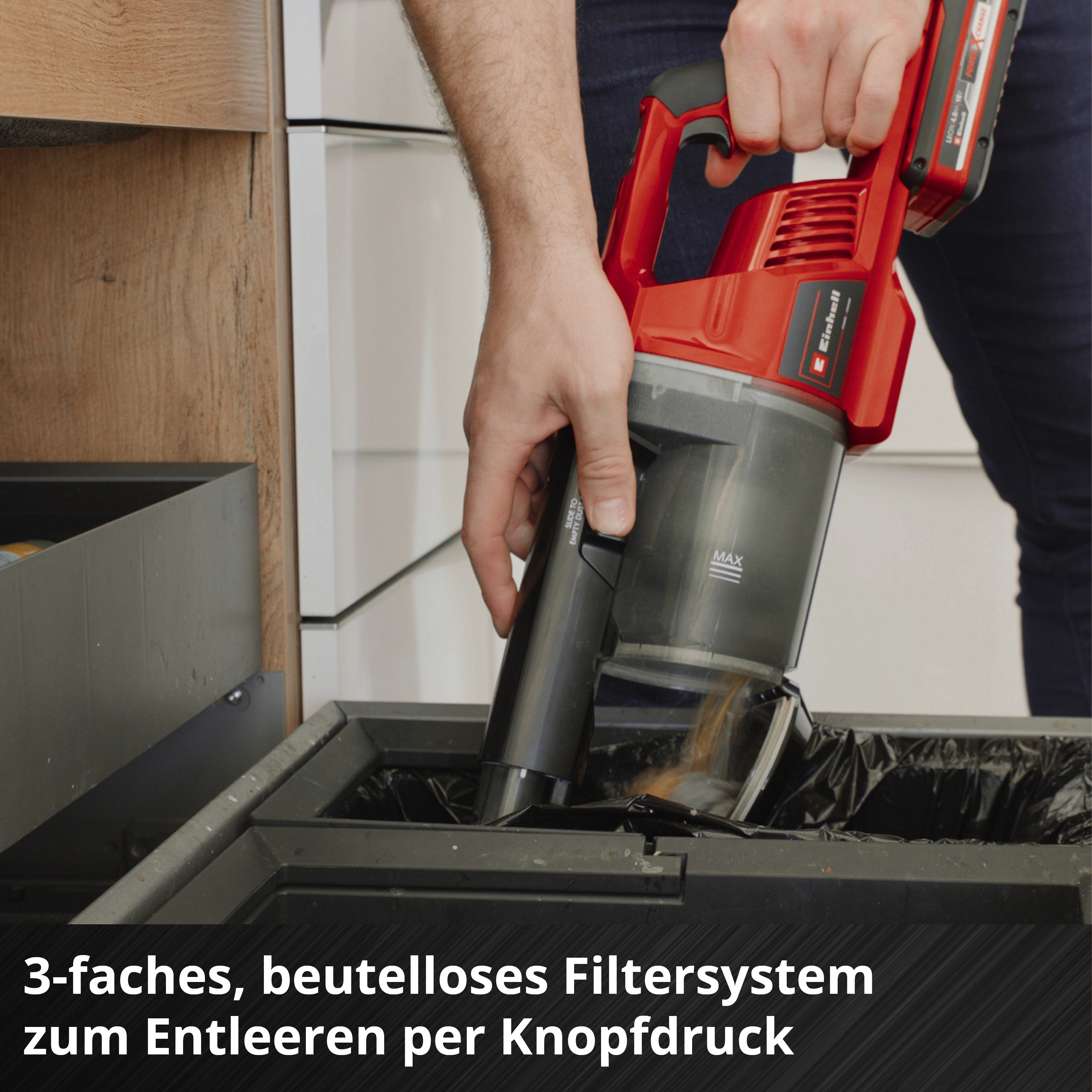 Person leert roten Akku-Staubsauger in Mülleimer. 3-faches Filtersystem.