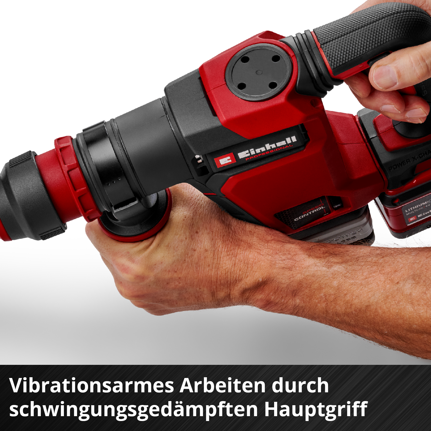 Ein Mann hält einen roten und schwarzen Bohrhammer mit zwei Händen.