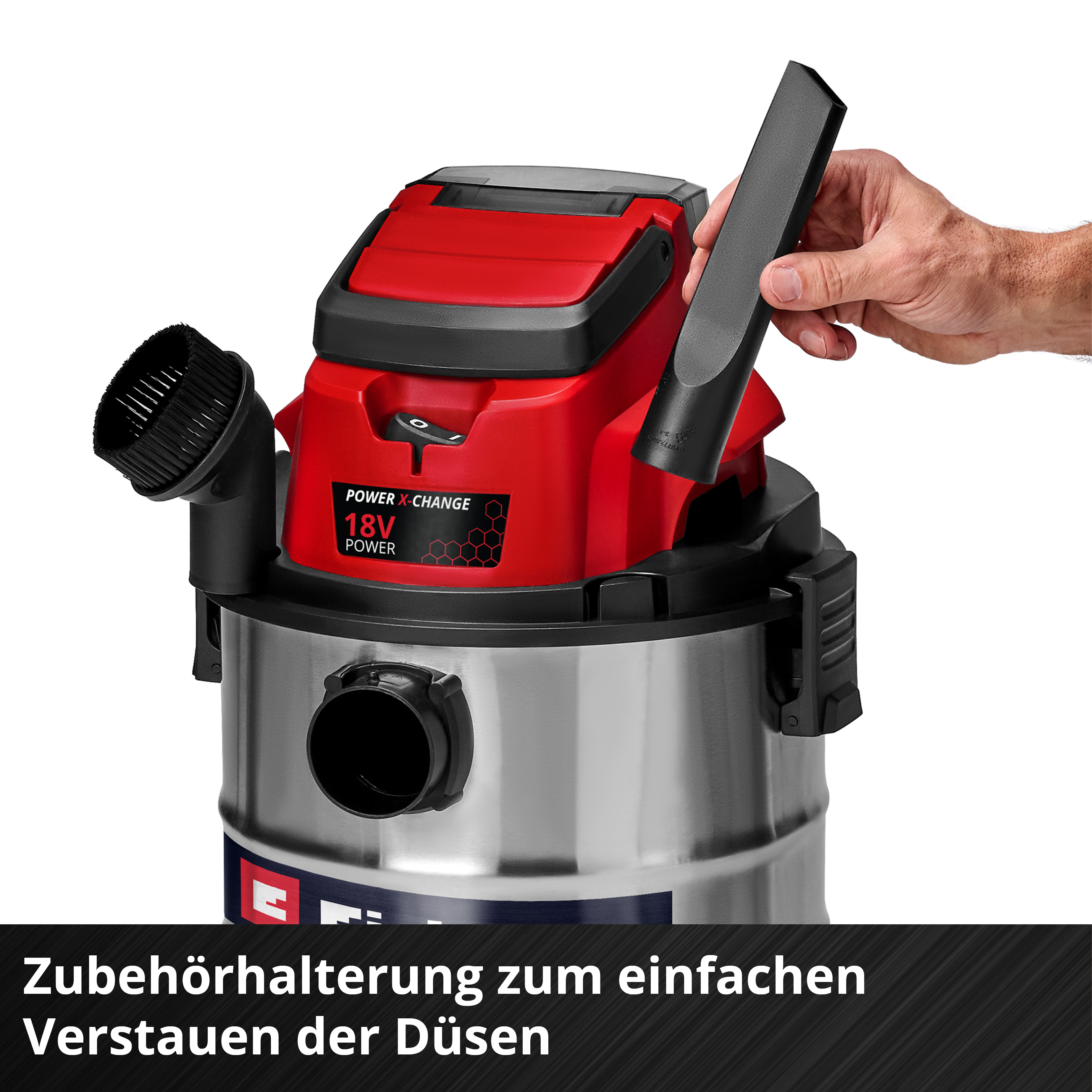 Ein Mann hält eine schwarze Düse für einen roten und silbernen Staubsauger.