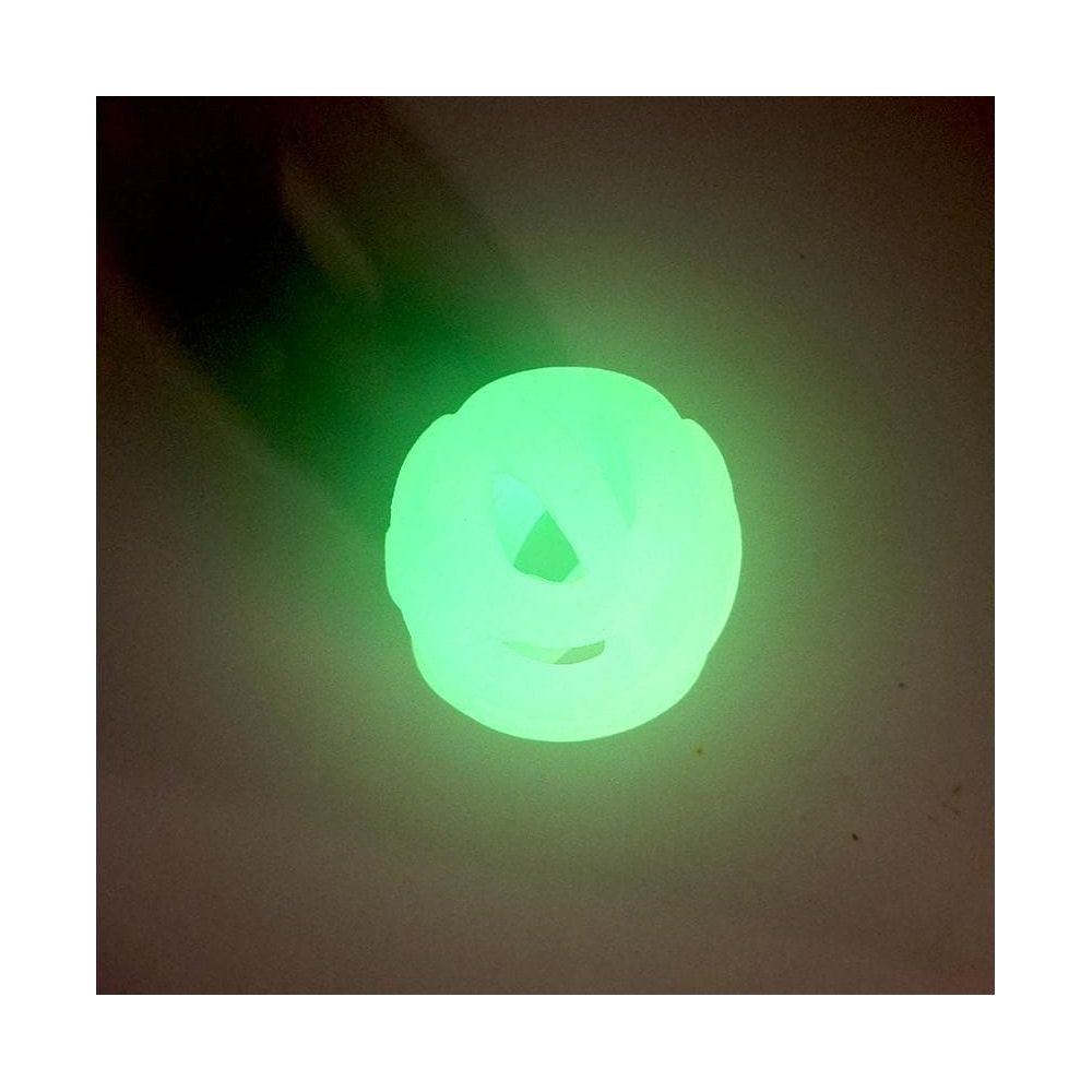 Una palla cava verde brillante riposa su una superficie grigia.