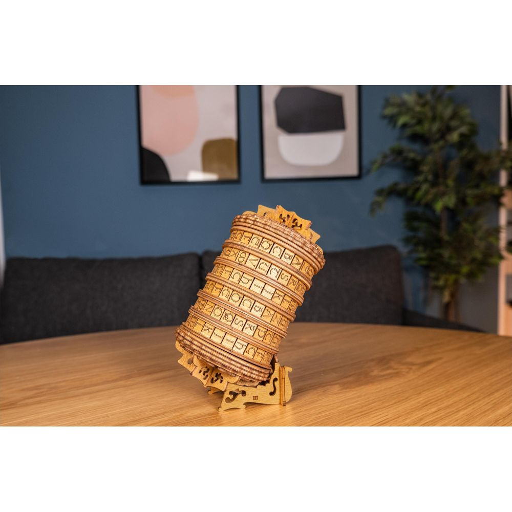 Una ruota cifrante in legno con lettere si erge su un tavolo.