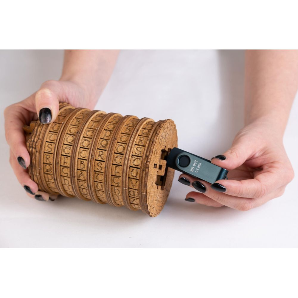 Mani tengono un cilindro di legno con quadranti a lettere e inseriscono una chiavetta USB.