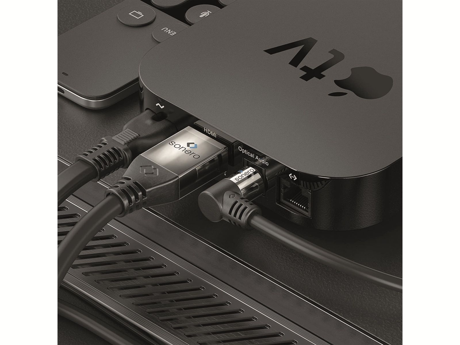 Un Apple TV noir avec des câbles HDMI et audio optique connectés.