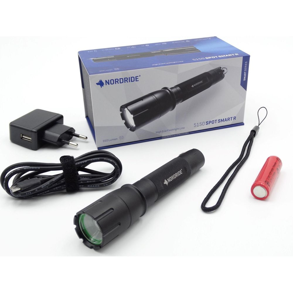 Lampe torche Nordride noire, chargeur, câble USB et batterie sur fond blanc.