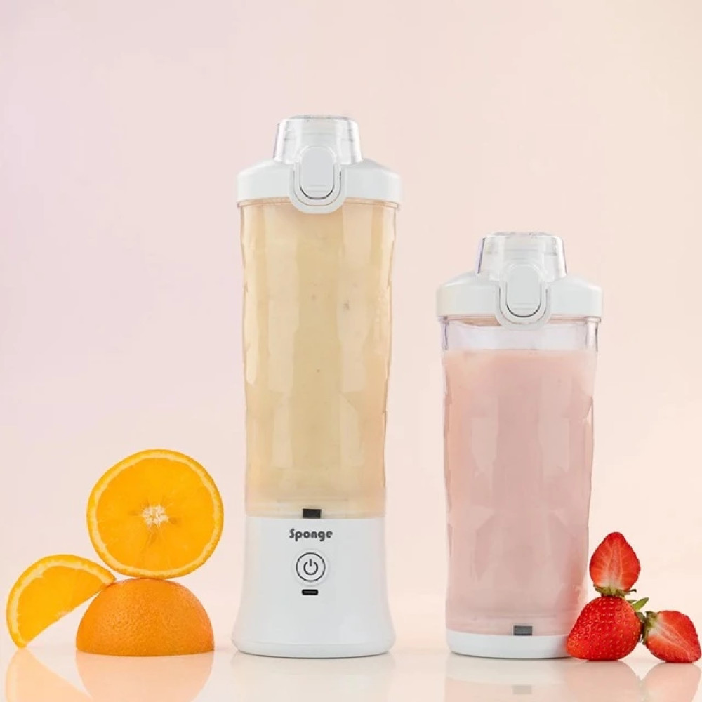 Due frullatori portatili, uno con frullato giallo, uno con frullato rosa, accanto ad arance e fragole.