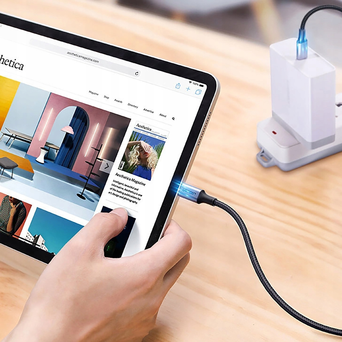 Tablet jest ładowany za pomocą kabla podłączonego do białej ładowarki.