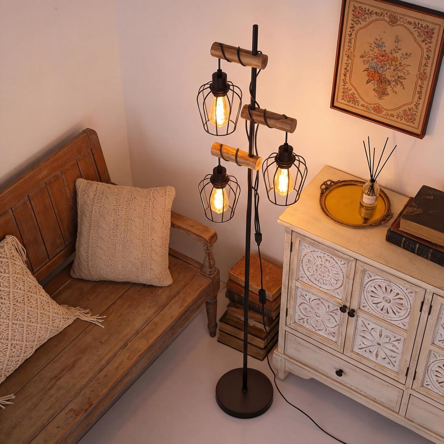 Una panca in legno con cuscini accanto a una lampada da terra con tre luci a gabbia.
