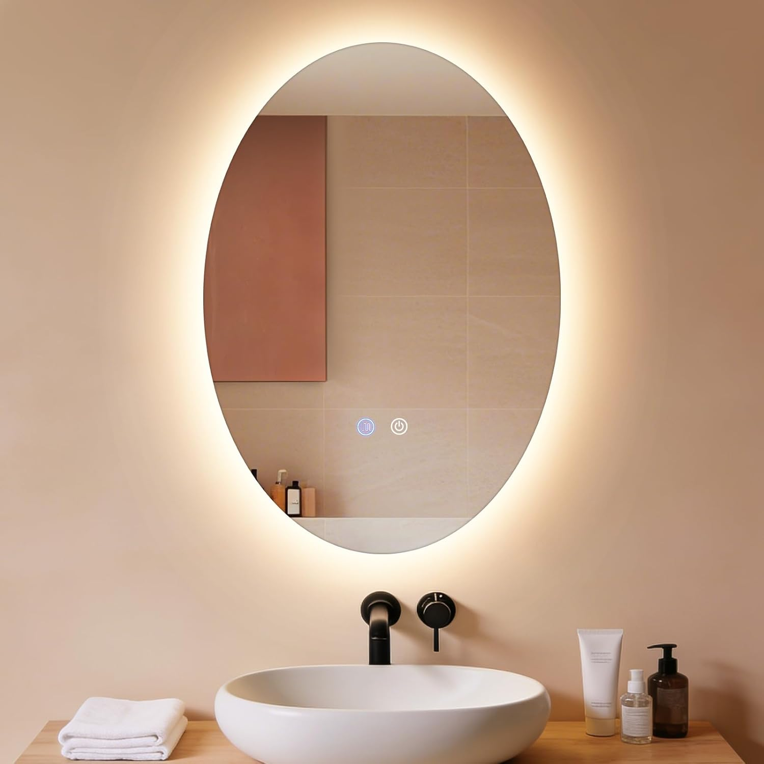 Specchio ovale con illuminazione a LED sopra un lavandino e rubinetteria bianchi.
