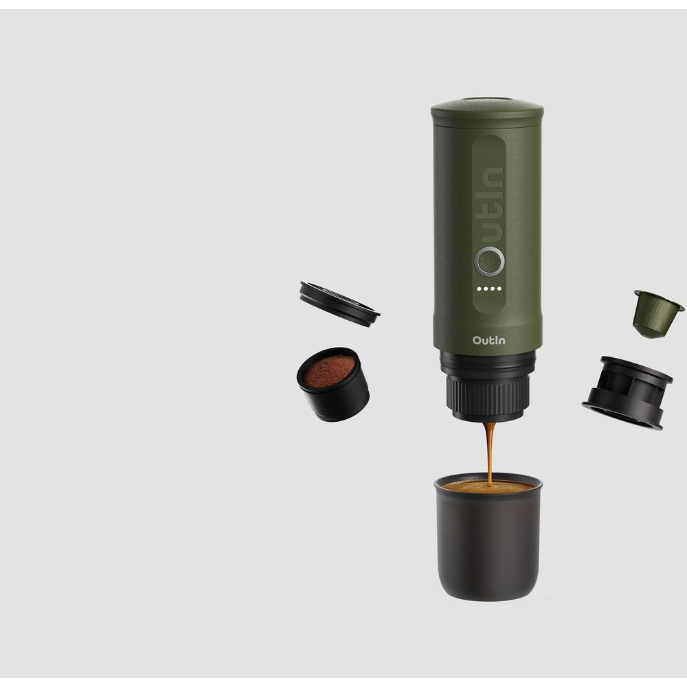 Zielona kawiarka parzy espresso do filiżanki. Kapsułki z kawą mieloną obok.