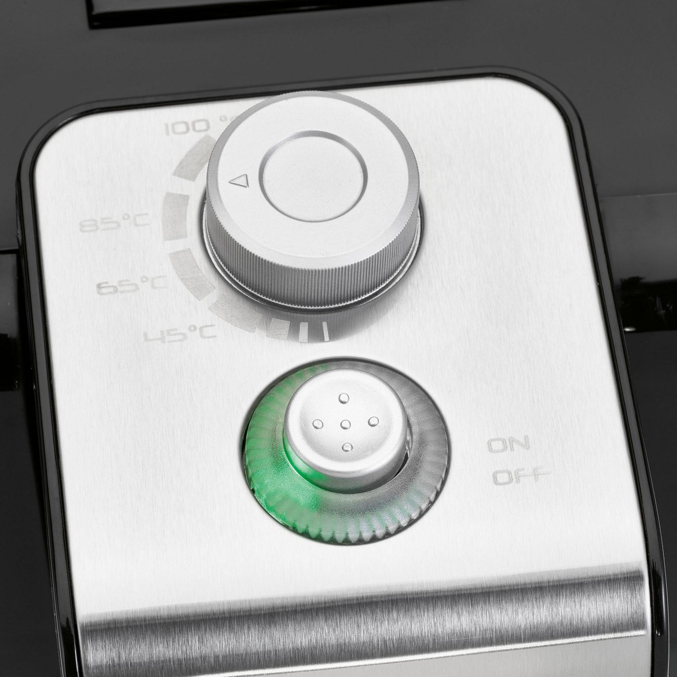 Zbliżenie panelu sterowania urządzenia z pokrętłem temperatury i podświetlanym przyciskiem.