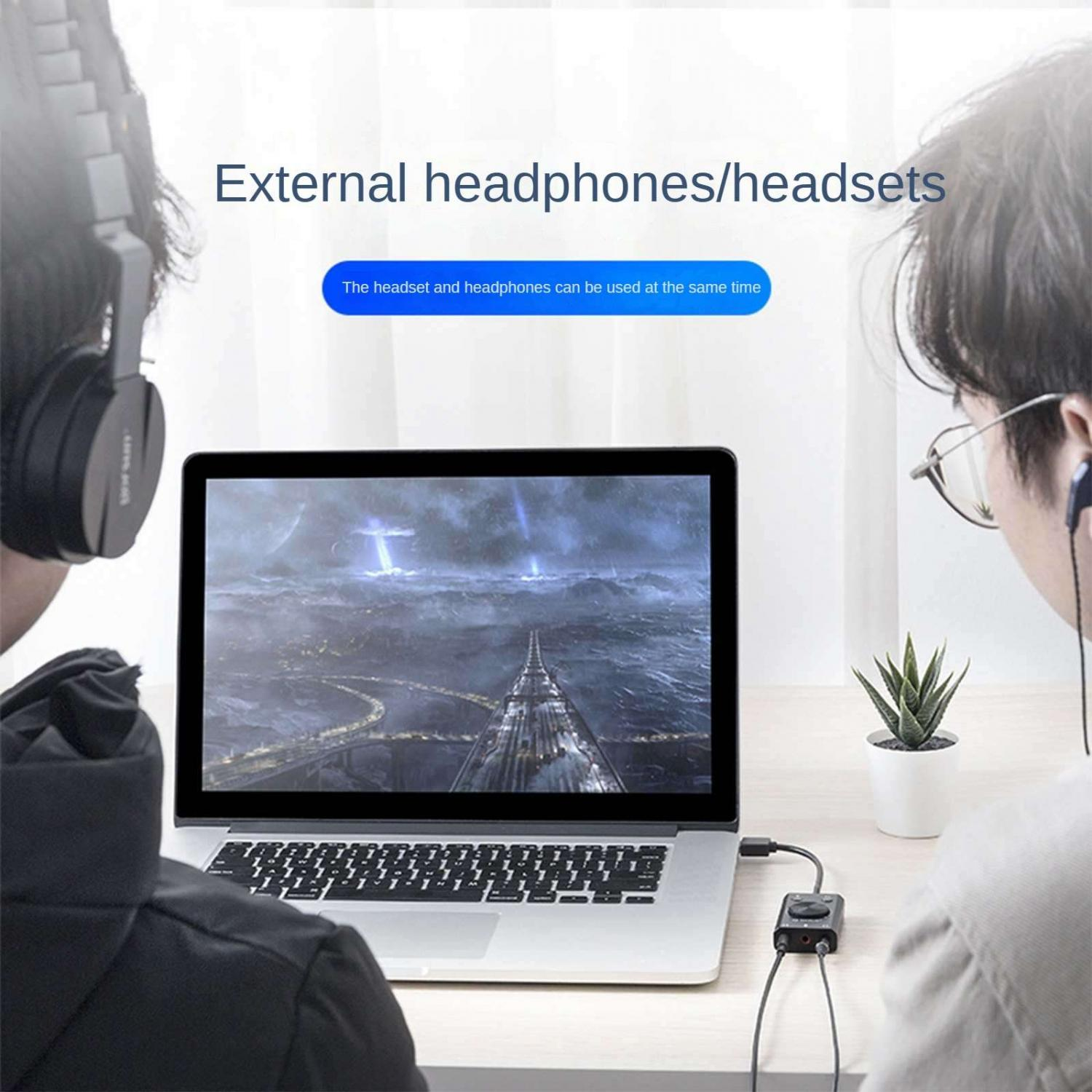 Zwei Personen tragen Kopfhörer vor einem Laptop mit einer dystopischen Stadtansicht.