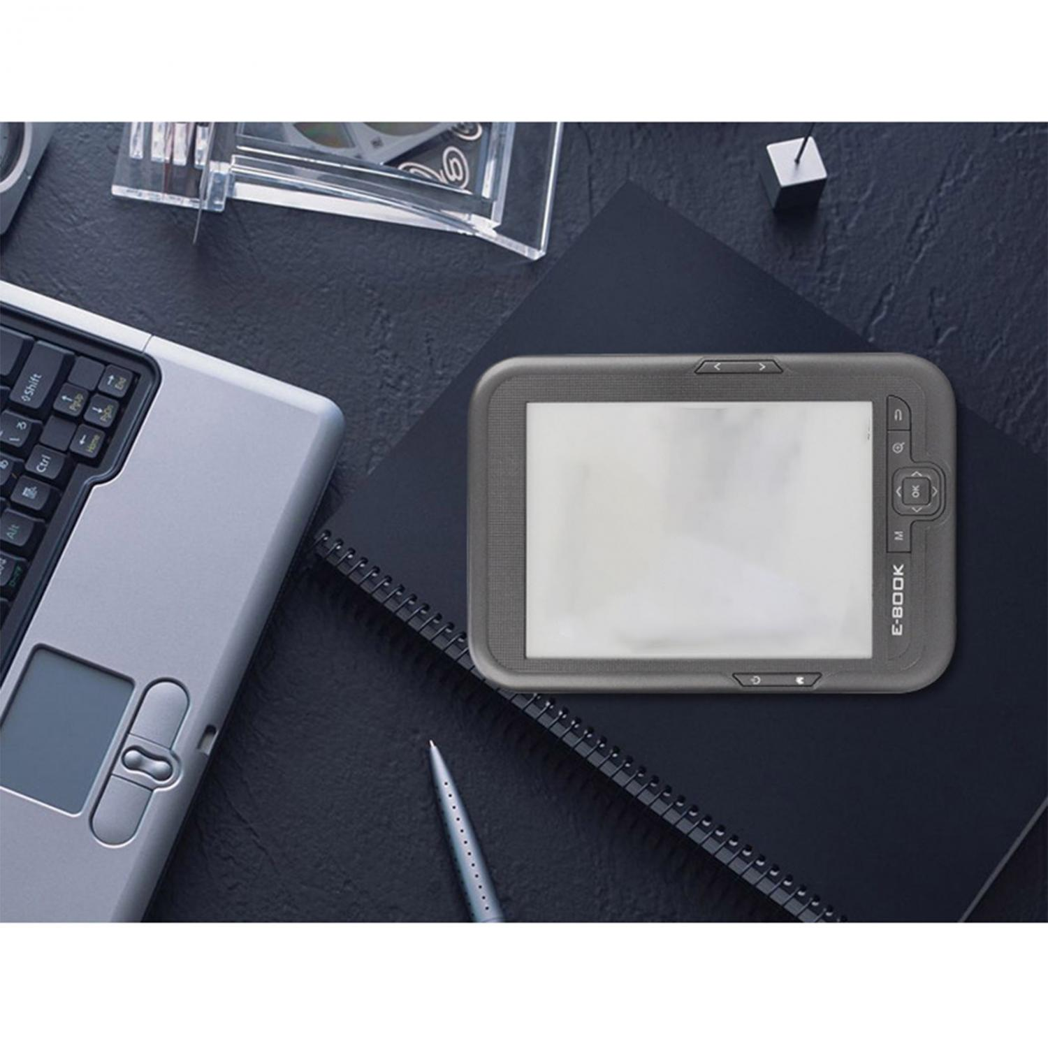 Ein E-Book-Reader liegt neben einem Laptop und einem Notizbuch.