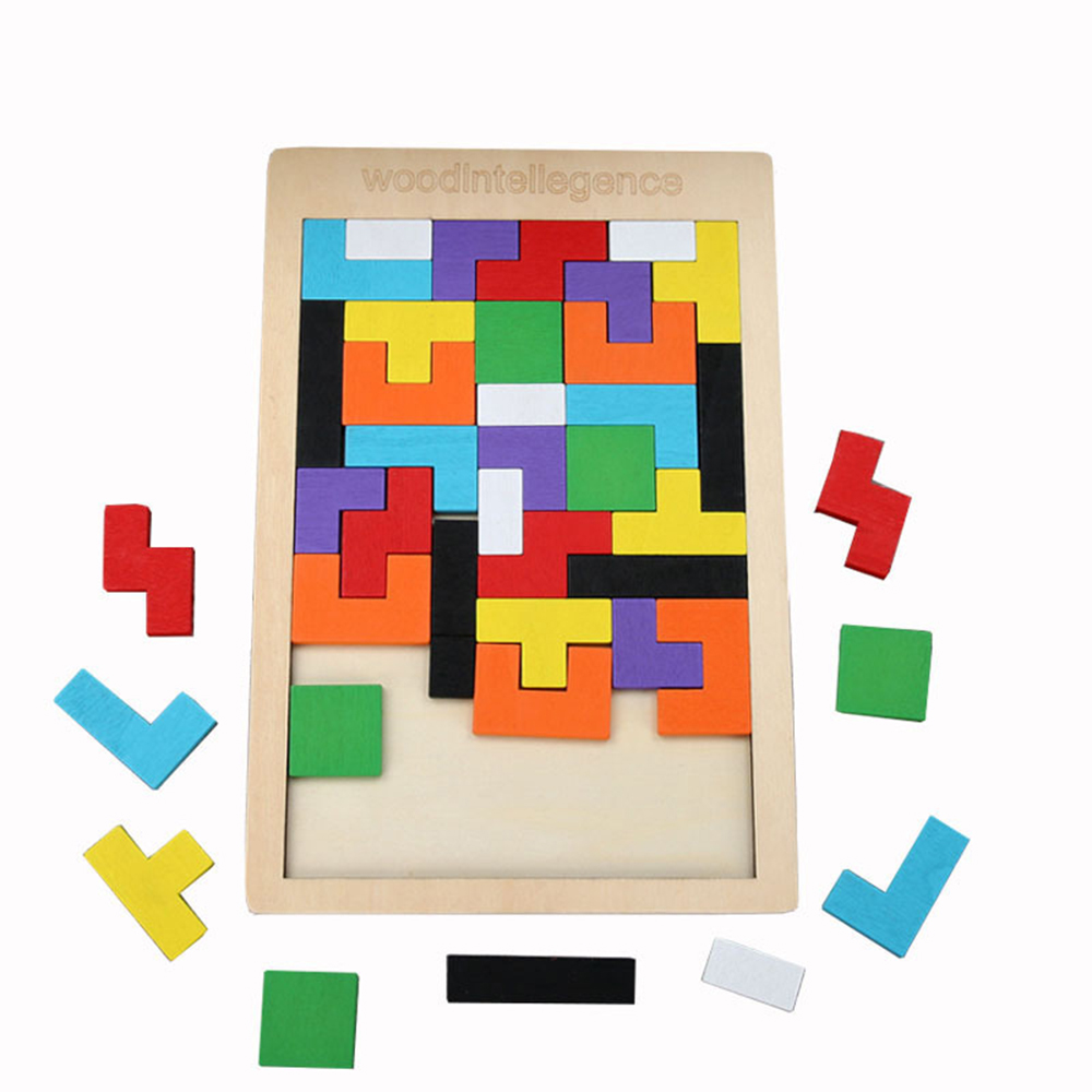 Buntes Holz-Tangram-Puzzle mit vielen Formen auf einer Holztafel, einige Teile liegen daneben.