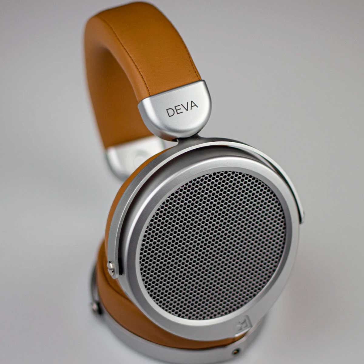 Auriculares de cuero marrón con detalles plateados y patrón de rejilla.