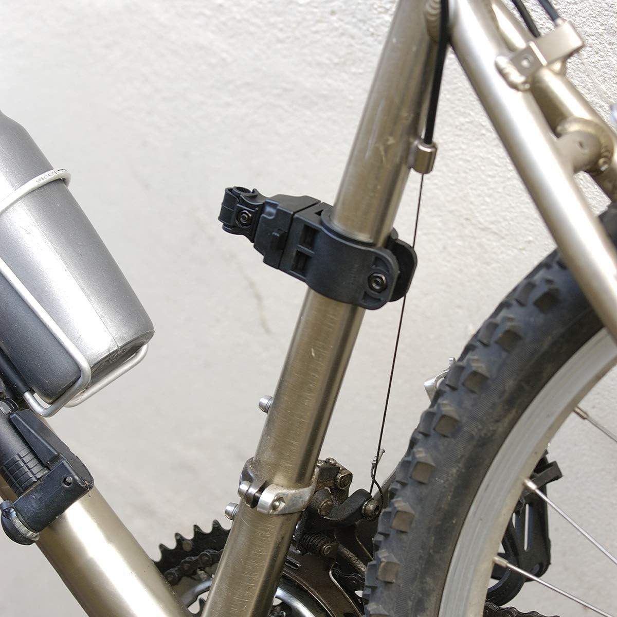 Primo piano di un telaio di bicicletta con portaborraccia, ruota e catena.