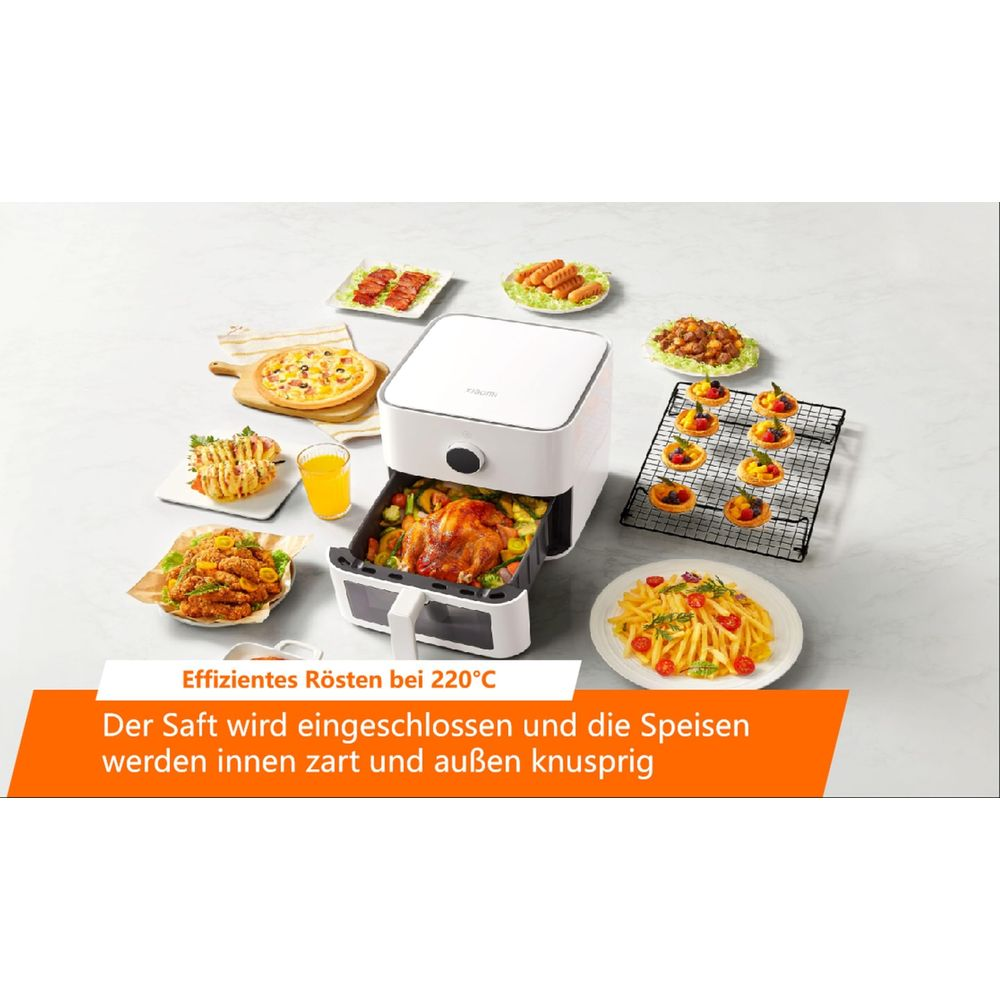 Biała frytkownica beztłuszczowa z pieczonym kurczakiem i warzywami, otoczona różnymi daniami.