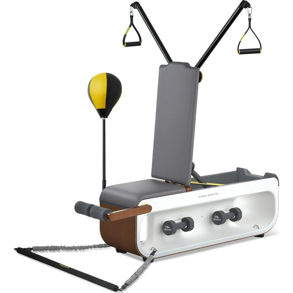 Urządzenie fitness z ławką, hantlami, workiem treningowym i uchwytami.