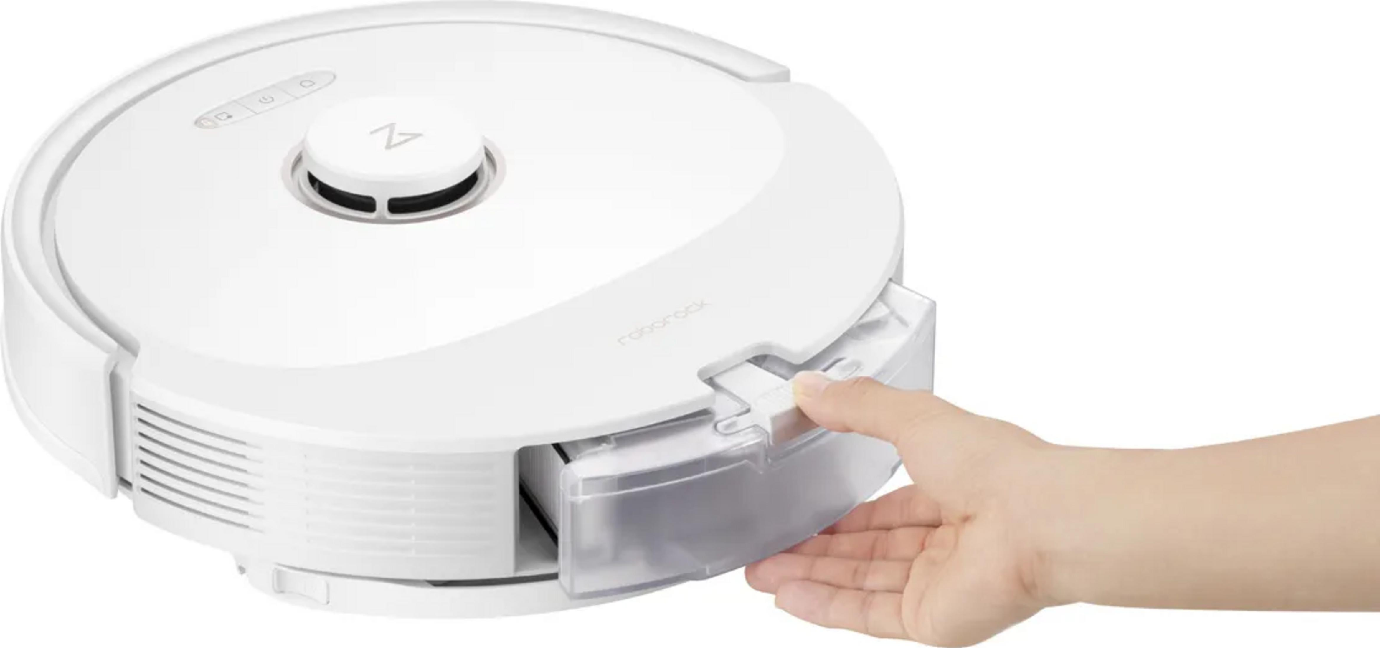 Beyaz bir robot süpürgenin toz haznesini bir el çekiyor.