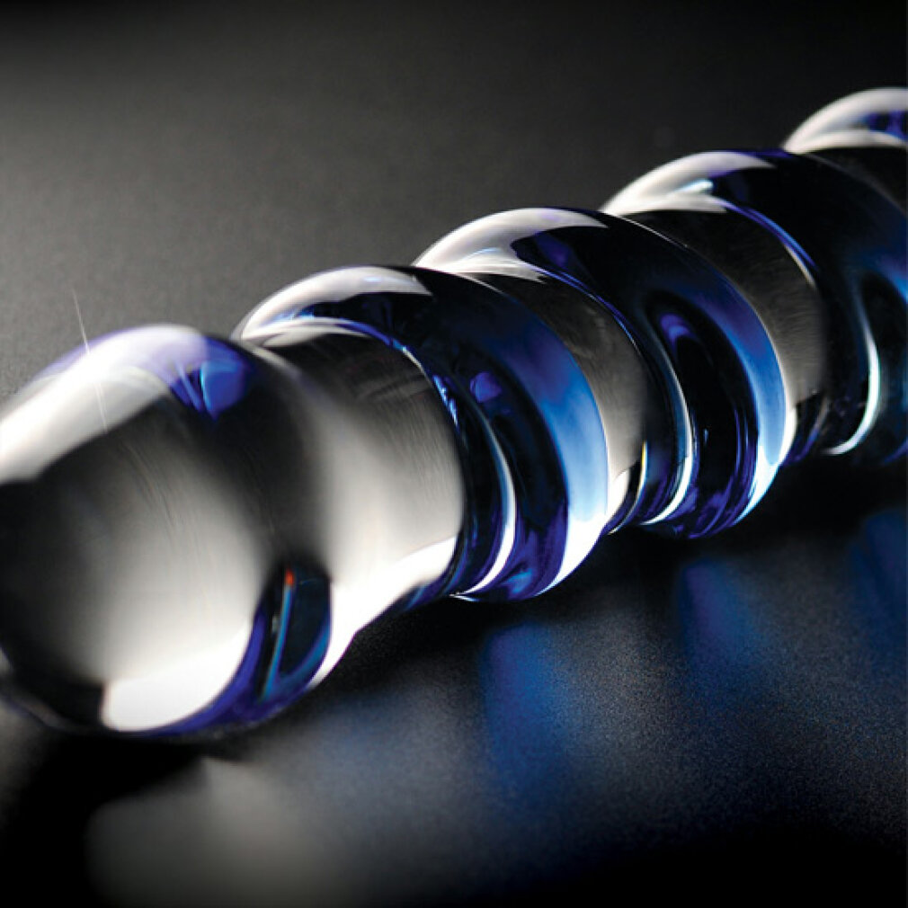 Ein spiralförmiges, blaues Glasobjekt liegt auf schwarzem Untergrund.