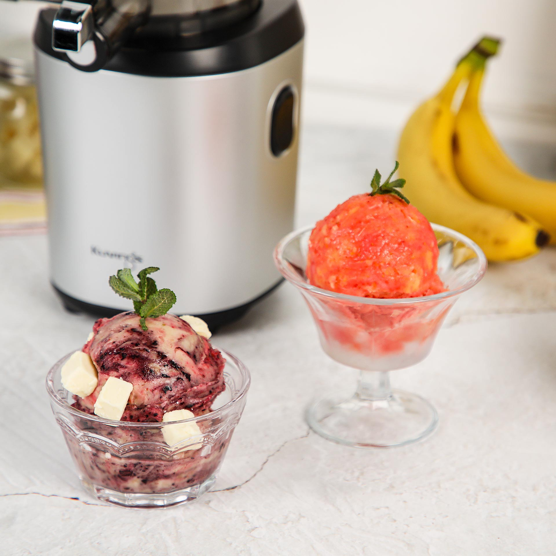 Eiscreme-Maschine mit Beeren- und Erdbeer-Eiscreme, Bananen und Minze.