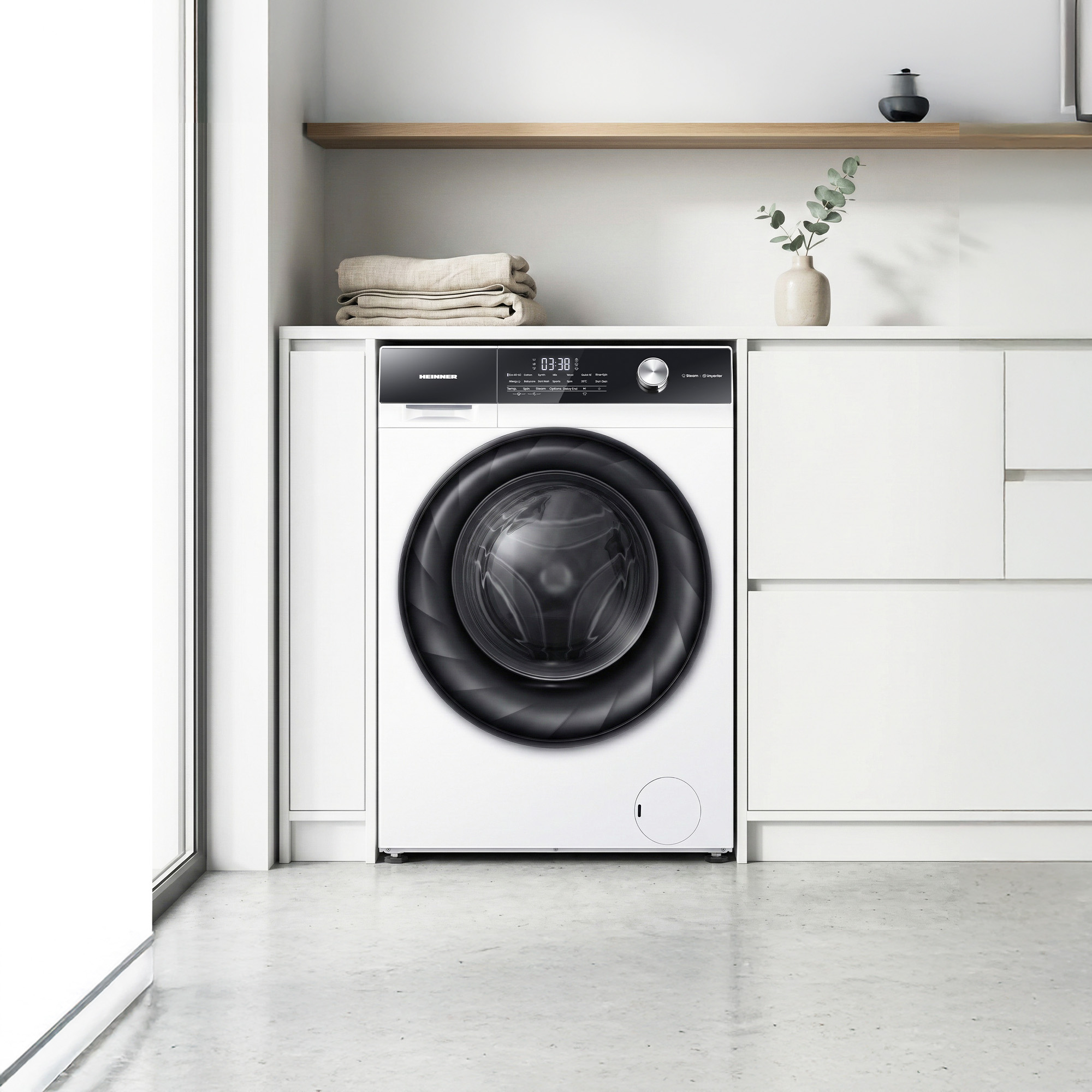 A white washing machine with a black door in a modern laundry room.