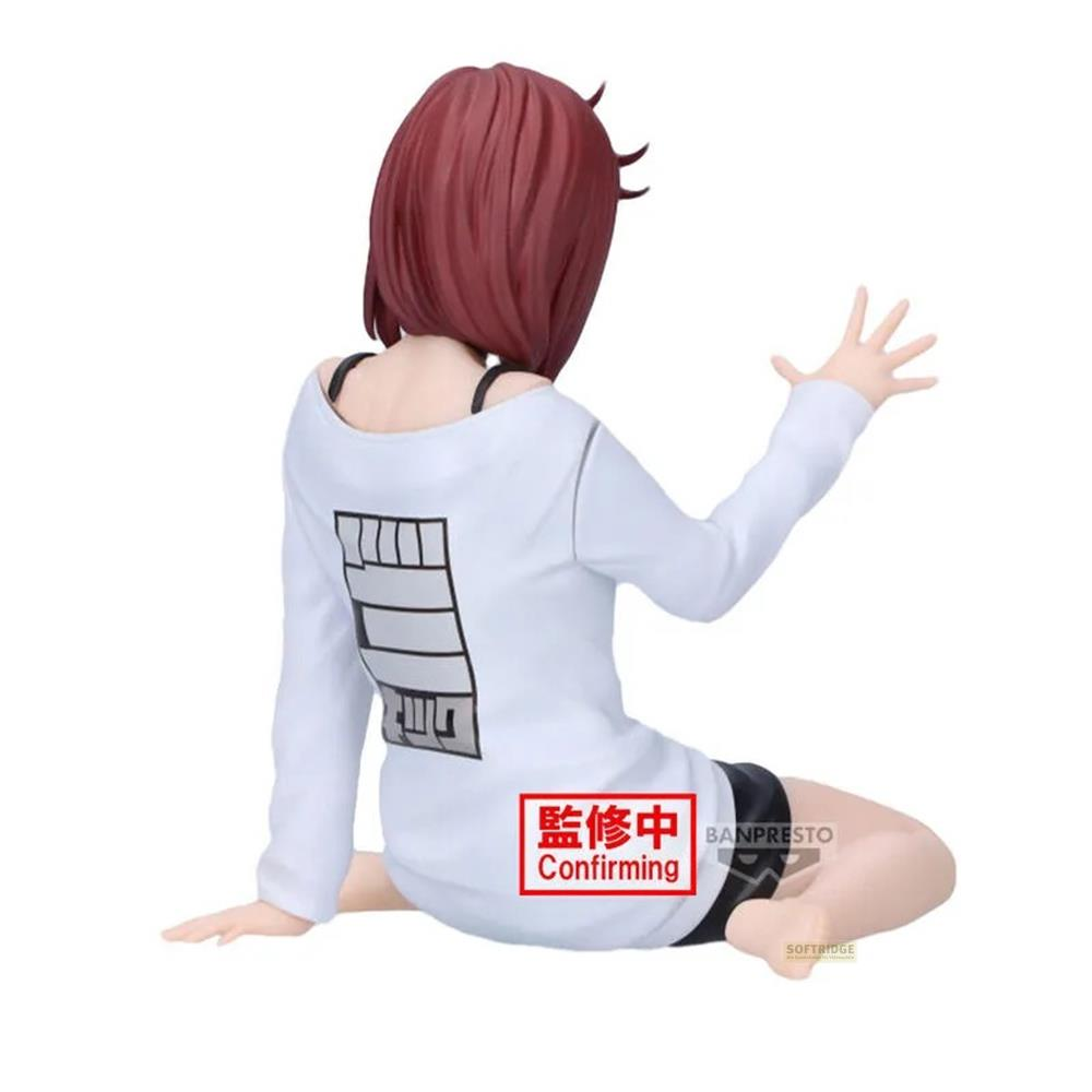 Figura pelirroja sentada, con camiseta blanca y estampado negro en la espalda.
