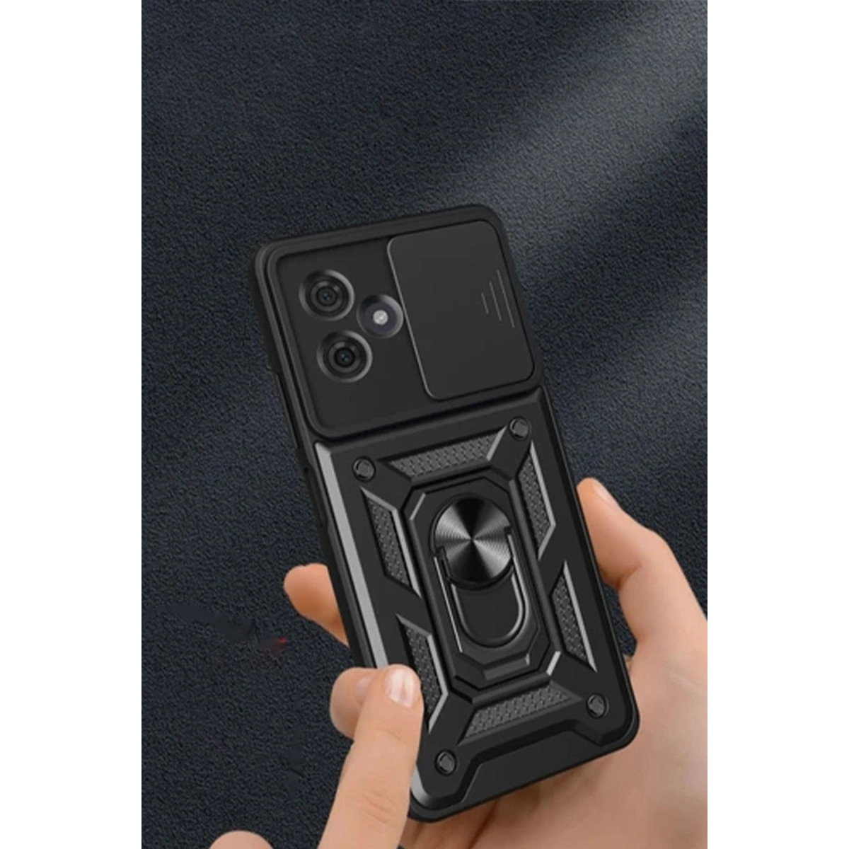 Kamera kapaklı ve halka tutuculu siyah telefon kılıfı, bir el tarafından tutuluyor.