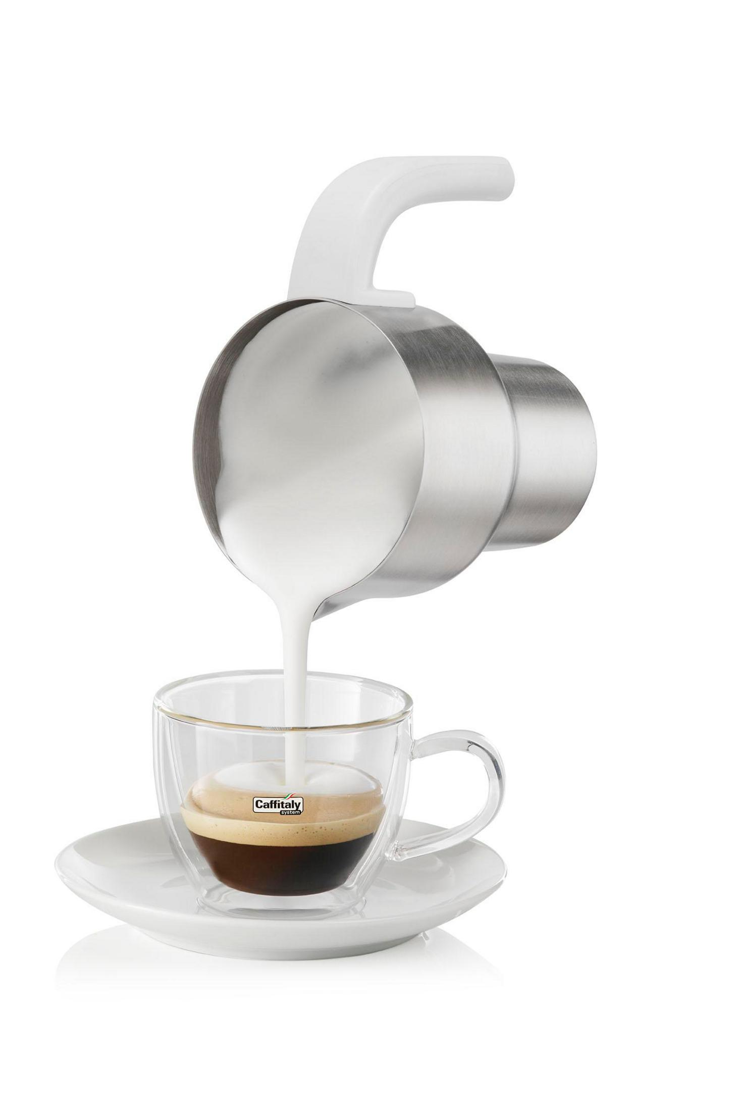 Milch wird in eine Espressotasse gegossen.