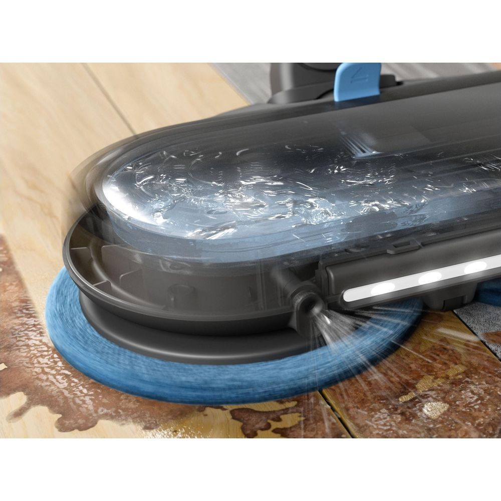 Un robot serpillière nettoie un plancher en bois avec une brosse rotative et pulvérisation.