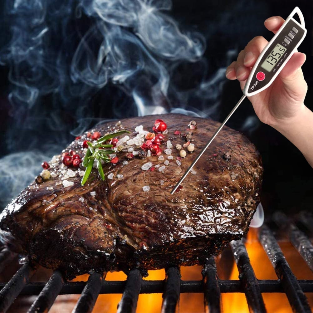 Ein Fleischthermometer misst 135,5°F in einem auf dem Grill gebratenen Steak.