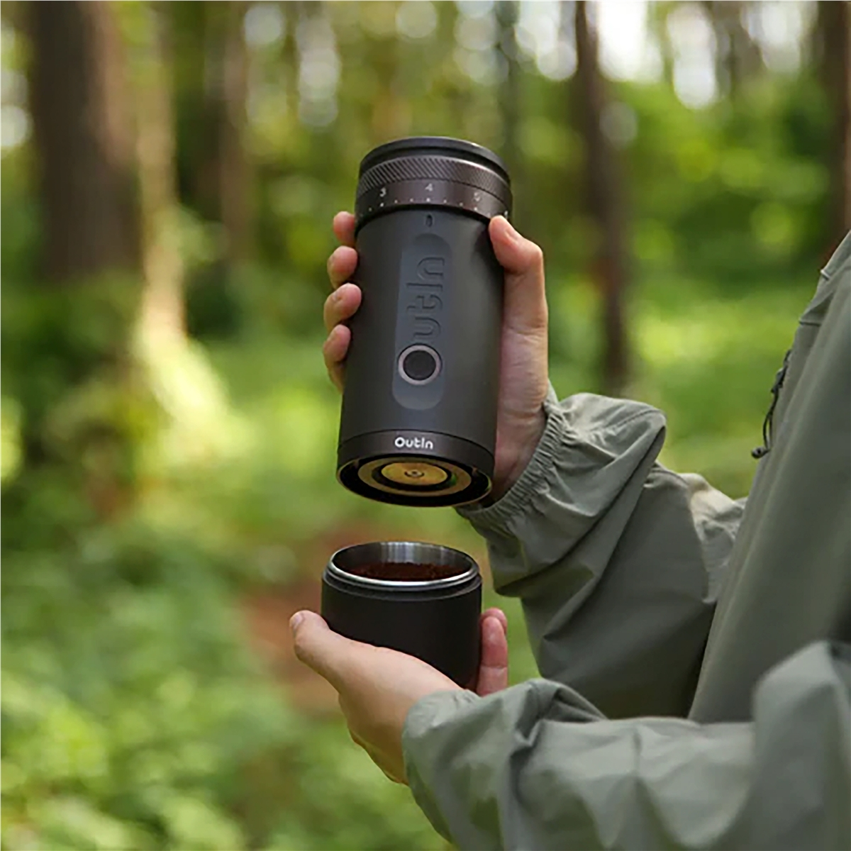 Osoba trzymająca czarny ekspres do kawy nad kubkiem fusów kawy.
