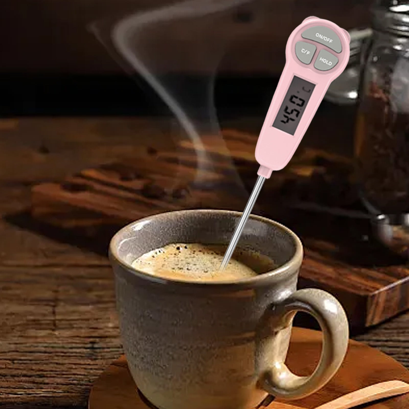 Ein pinker Thermometer misst die Temperatur einer heißen Kaffeetasse.