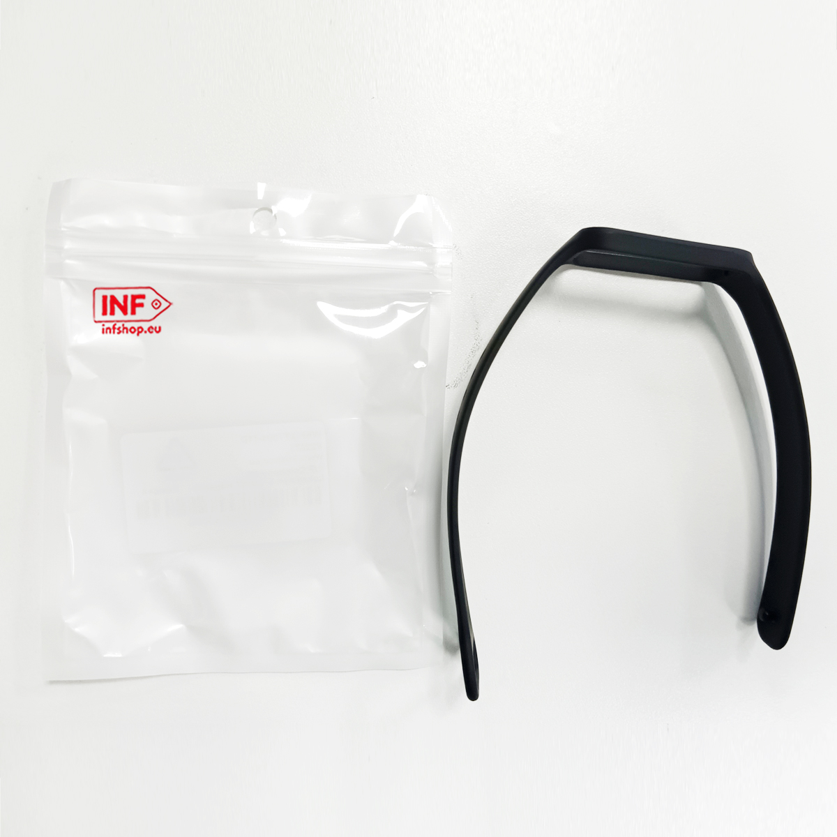 Czarna opaska na nadgarstek i białe opakowanie.