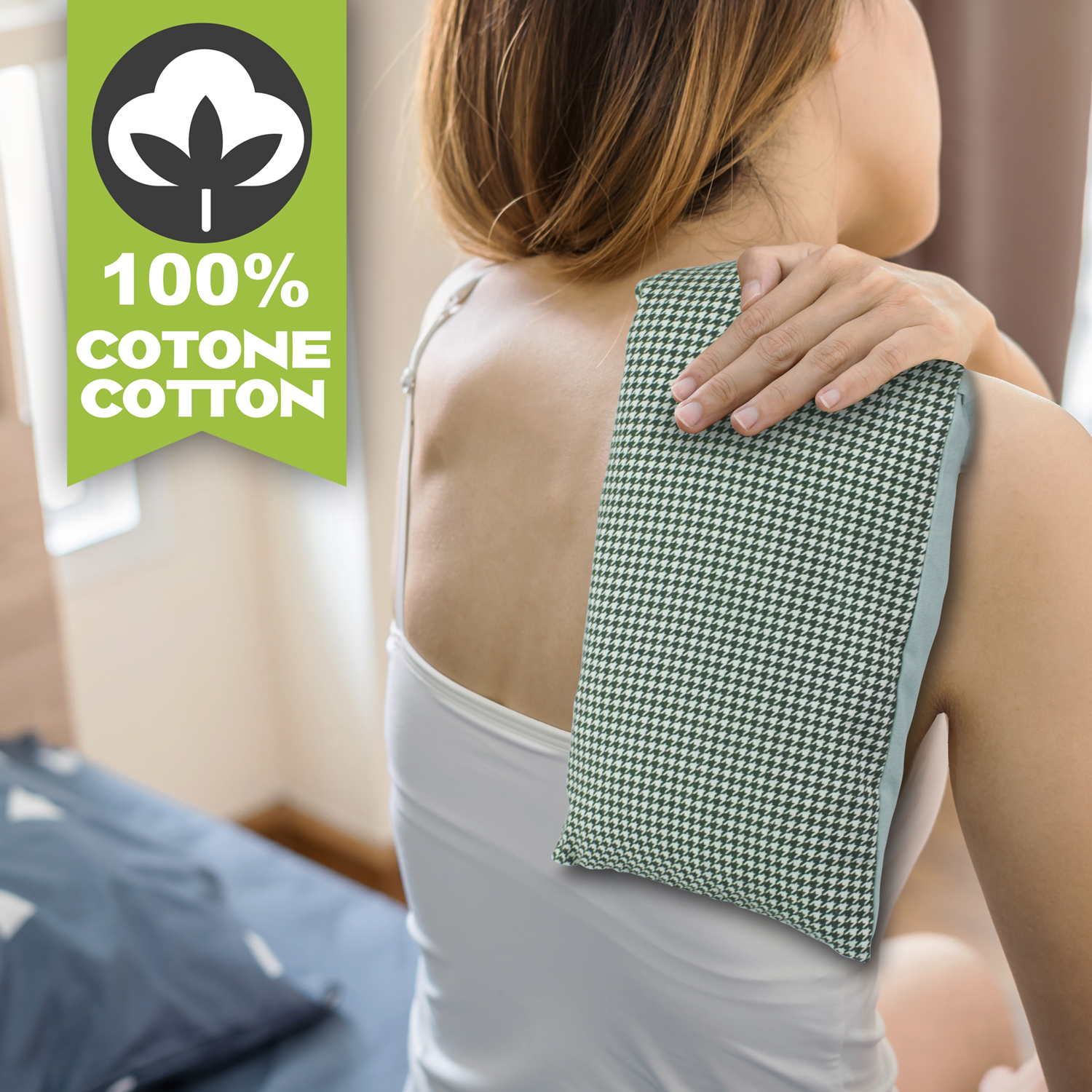 Una donna si mette una borsa dell'acqua calda a pied-de-poule sulla spalla. Etichetta: 100% Cotone.