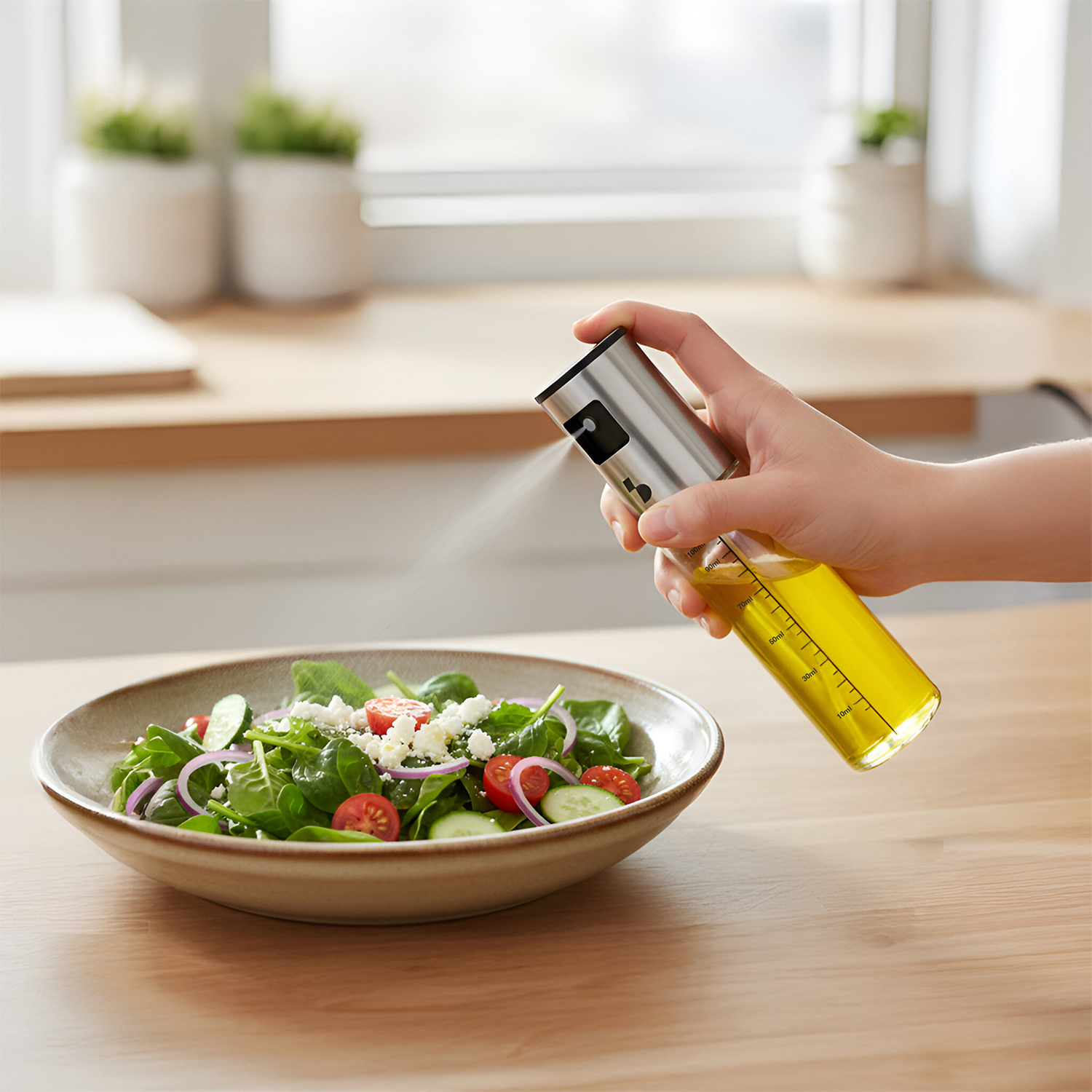 Una mano spruzza olio d'oliva con uno spruzzino argentato su un'insalata in una ciotola.