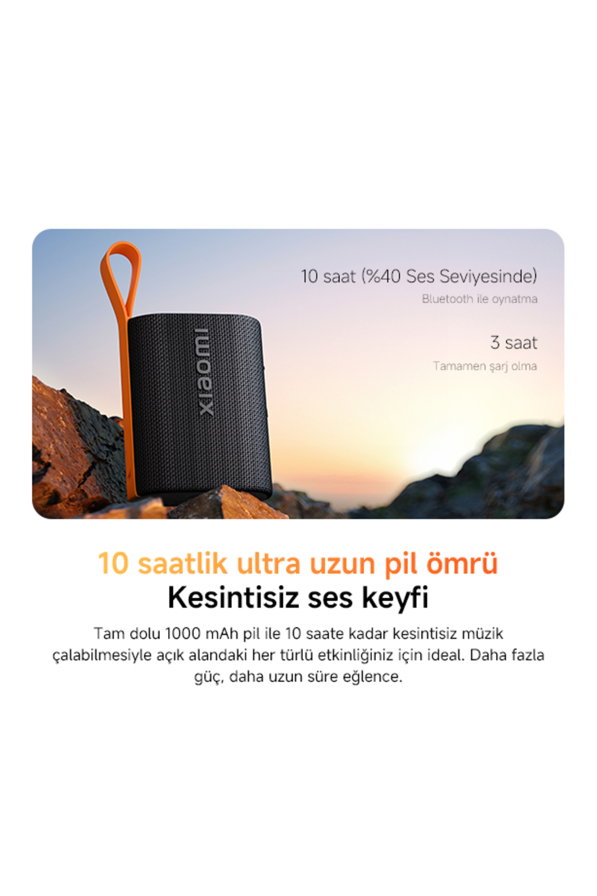 Schwarzer Bluetooth-Lautsprecher mit orangefarbenem Band auf Felsen, Sonnenuntergangshintergrund.