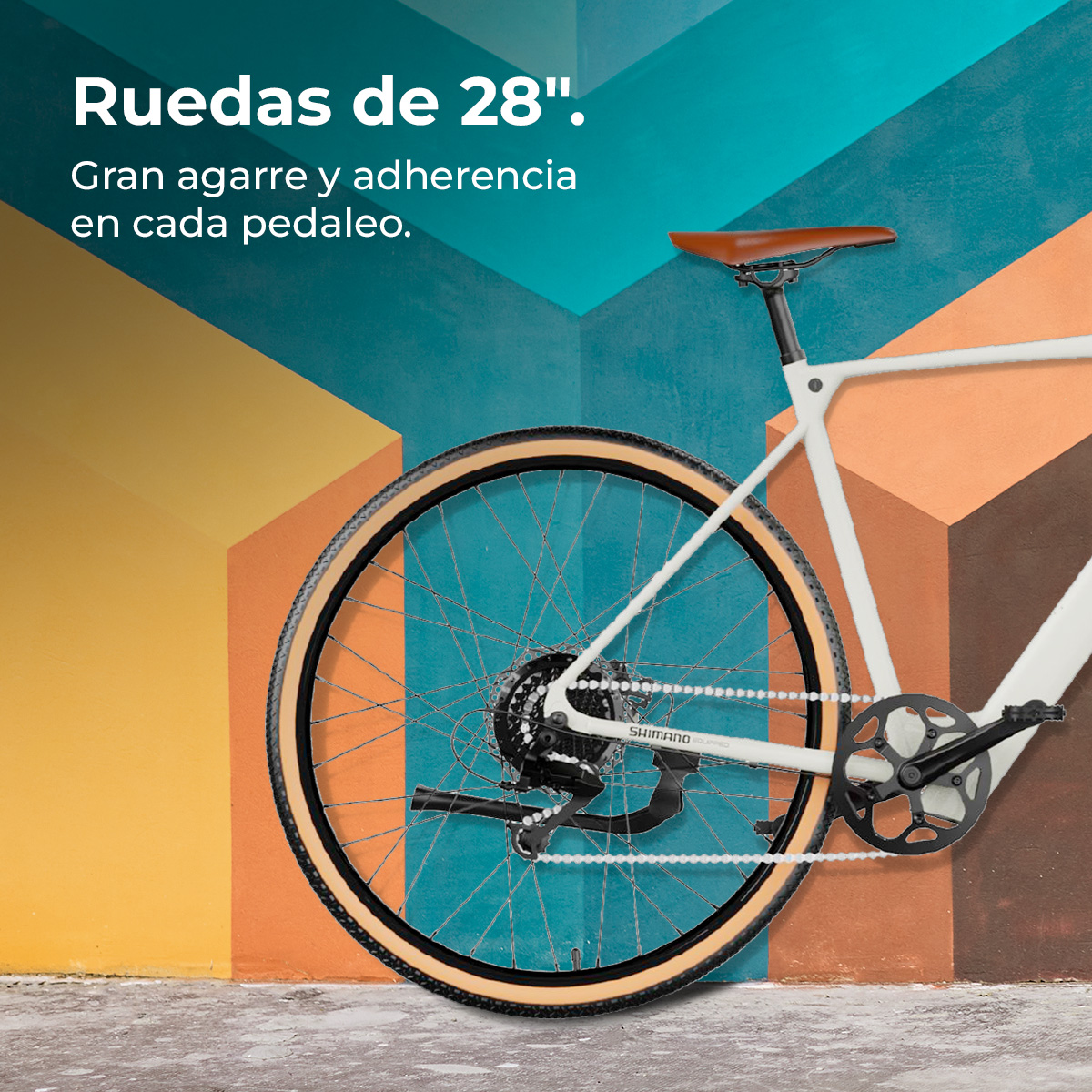 Una bicicleta blanca de 28 pulgadas delante de una pared colorida.