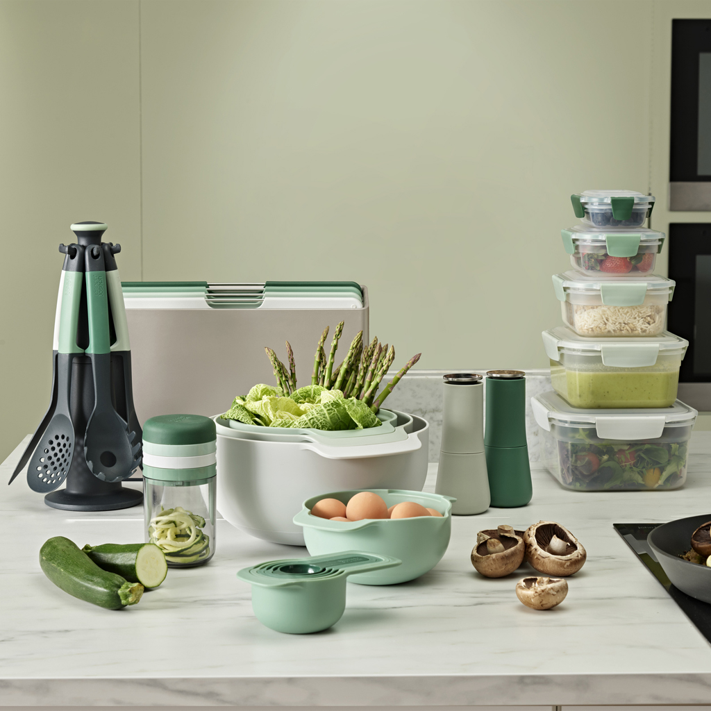 Utensili e ingredienti da cucina: spirale, ciotole, asparagi, uova, zucchine, funghi, contenitori.
