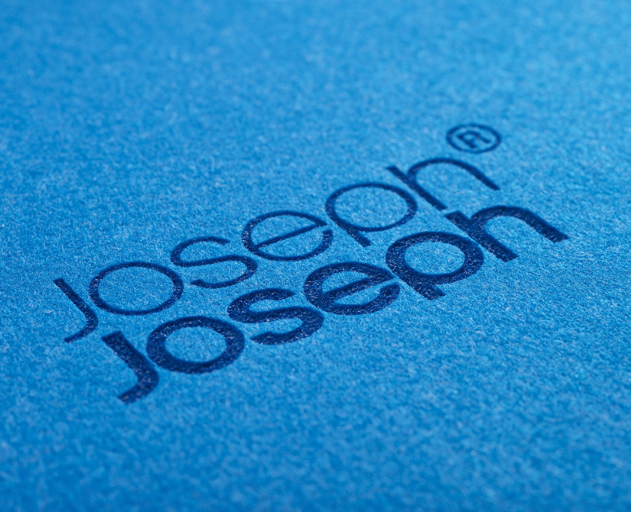 Kabartmalı "Joseph Joseph" logosu ve R sembolü bulunan mavi bez.