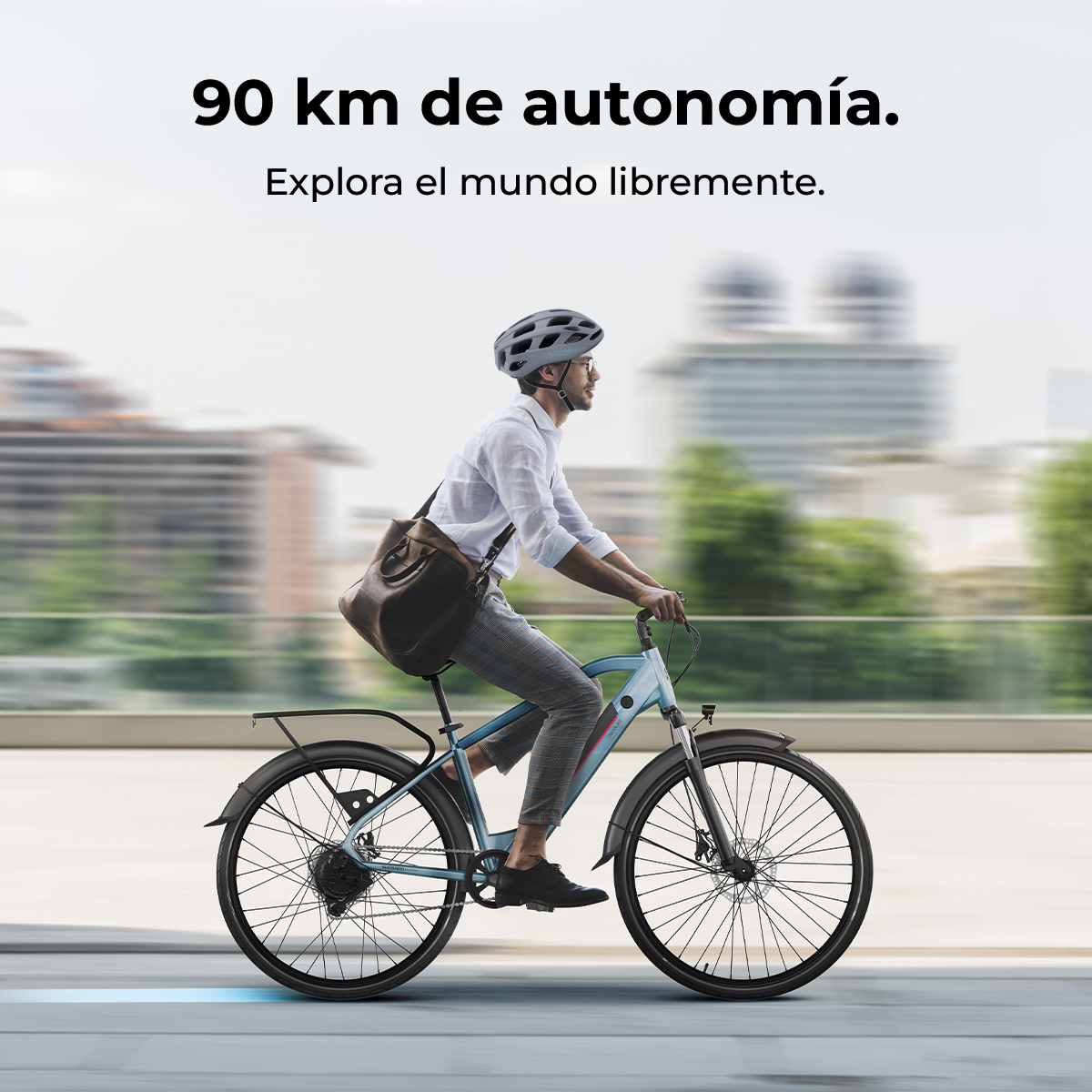 Uomo guida e-bike azzurro con casco e borsa, sfondo urbano.