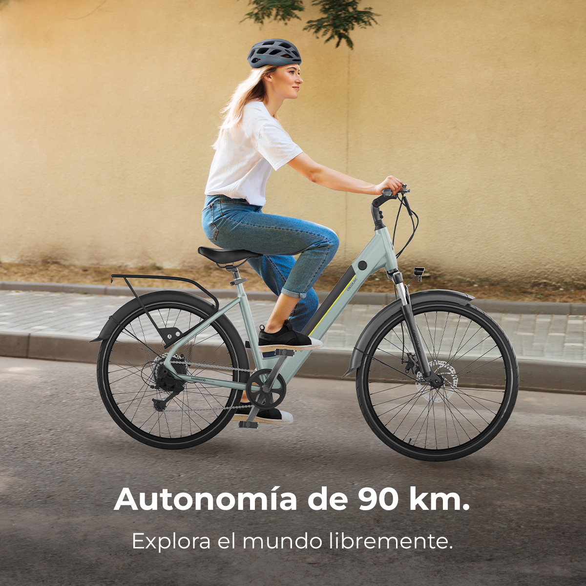 Eine Frau mit Helm fährt ein hellgrünes Fahrrad auf einer Straße.