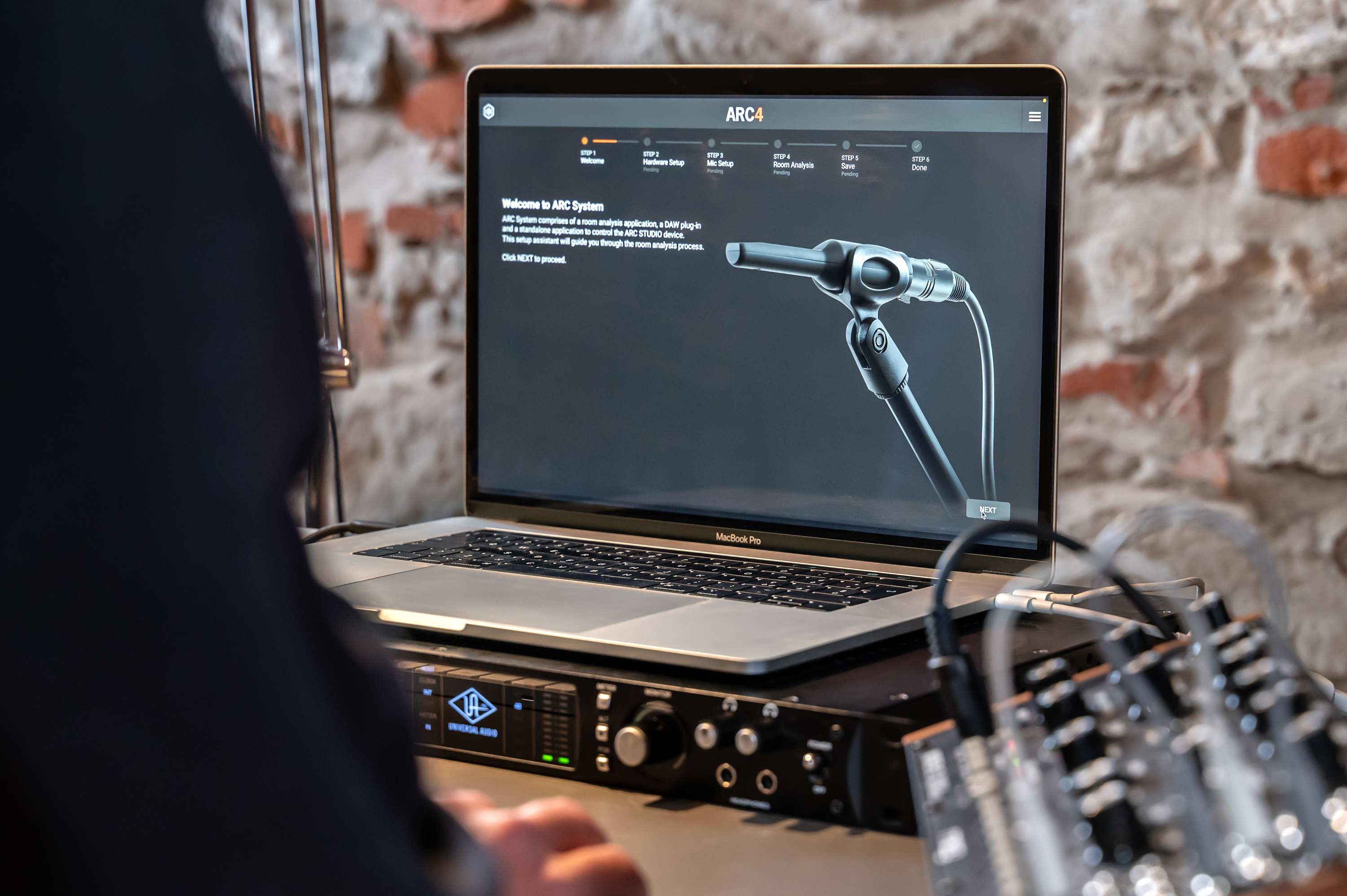Un MacBook Pro mostra il software ARC4 che guida un'impostazione di analisi della stanza.
